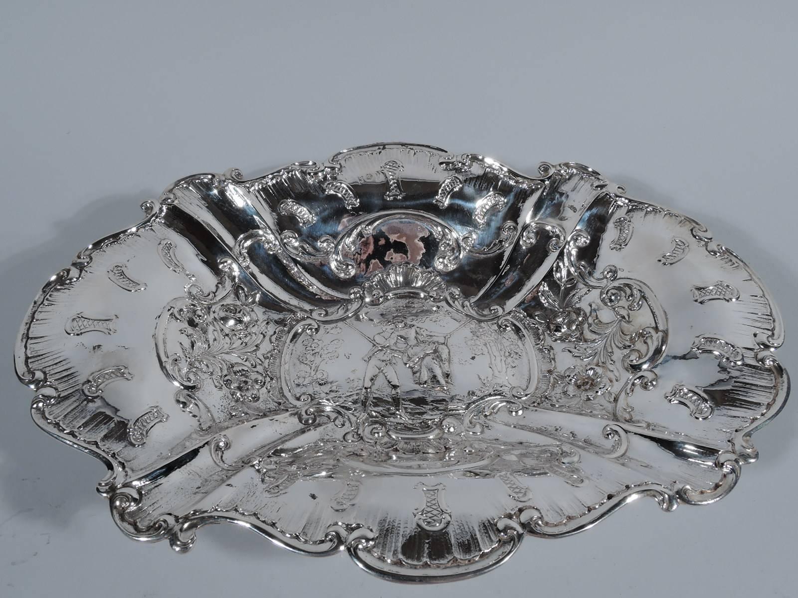 German 800 silver bowl, circa 1900. Ovoid with wide and flared mouth and four paw supports with leaf mounts. Chased and repousse scrolls and leaves. In well a gallant pushes a lady on a swing in a bower. A popular period motif sweetly portrayed. Rim