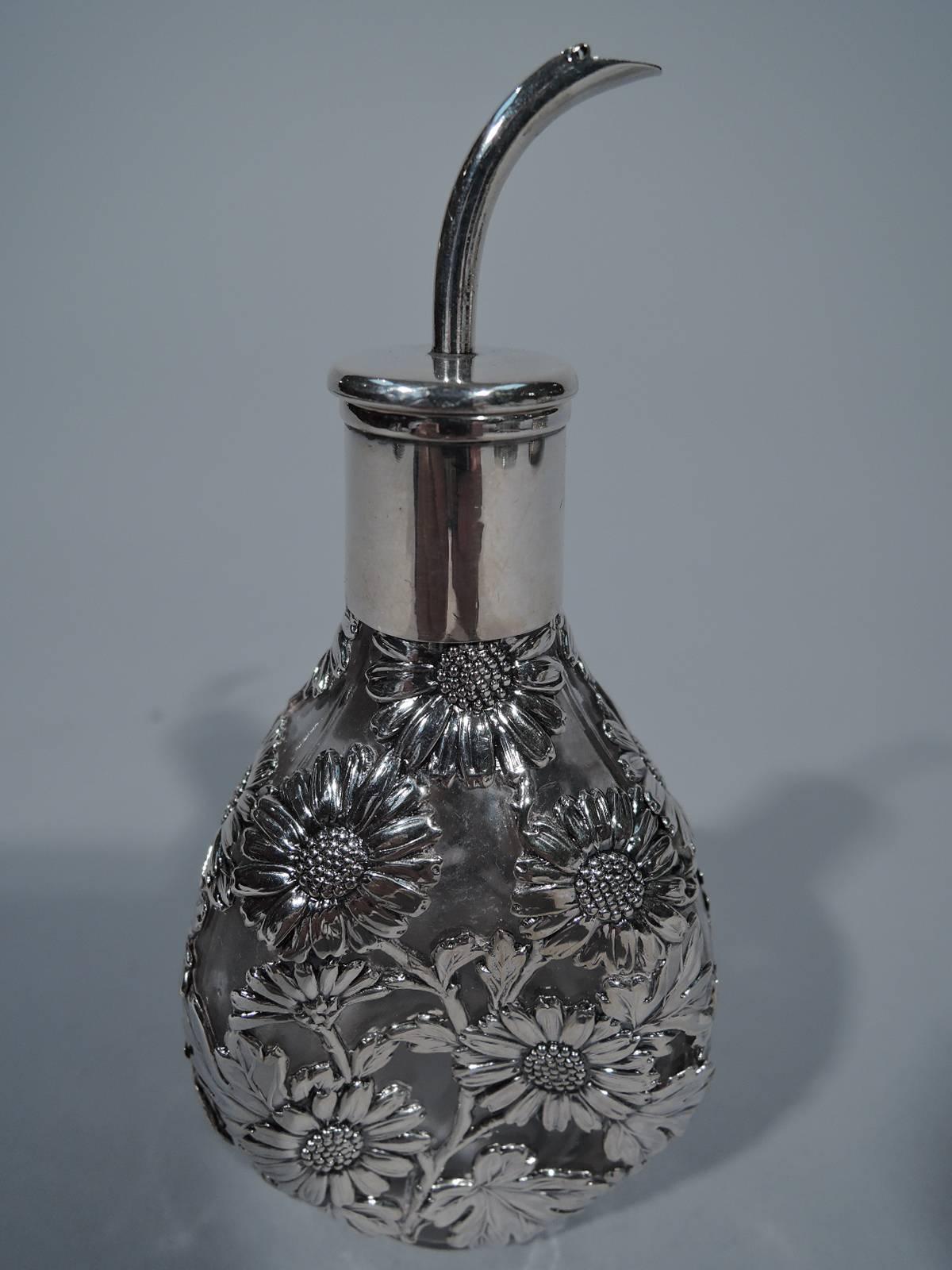 Chinese export glass perfume with silver overlay, circa 1900. Clear glass bottle with three pinched sides. Silver overlay in form of daisies. Cylindrical neck in silver collar. Stopper also silver with flat top and short cork plug. Unmarked.