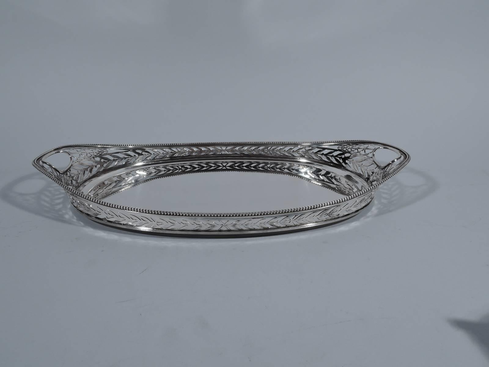 Dutch 833 silver tray, 1912. Oval well and asymmetrical gallery with pierced imbricated leaves and ovals and beaded rim. Cutout oval end handles. A pretty and characteristic piece from the early 20th century. Hallmark includes date letter. Weight: