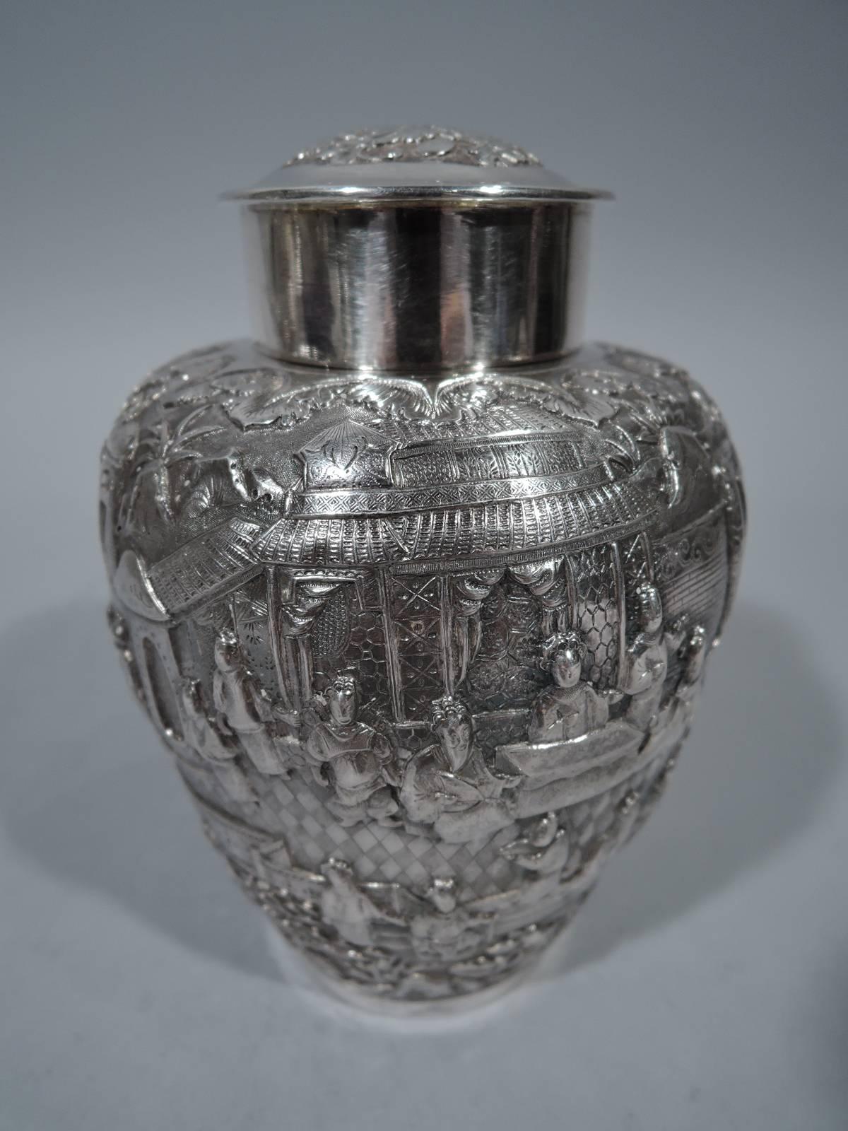 Chinese export silver tea caddy, circa 1900. Ovoid ginger jar form with short neck and cover. Dense frieze peopled with warriors and sages against a background of pavilions, bamboo, and blossoming prunus branches. Rectangular frame with interlaced
