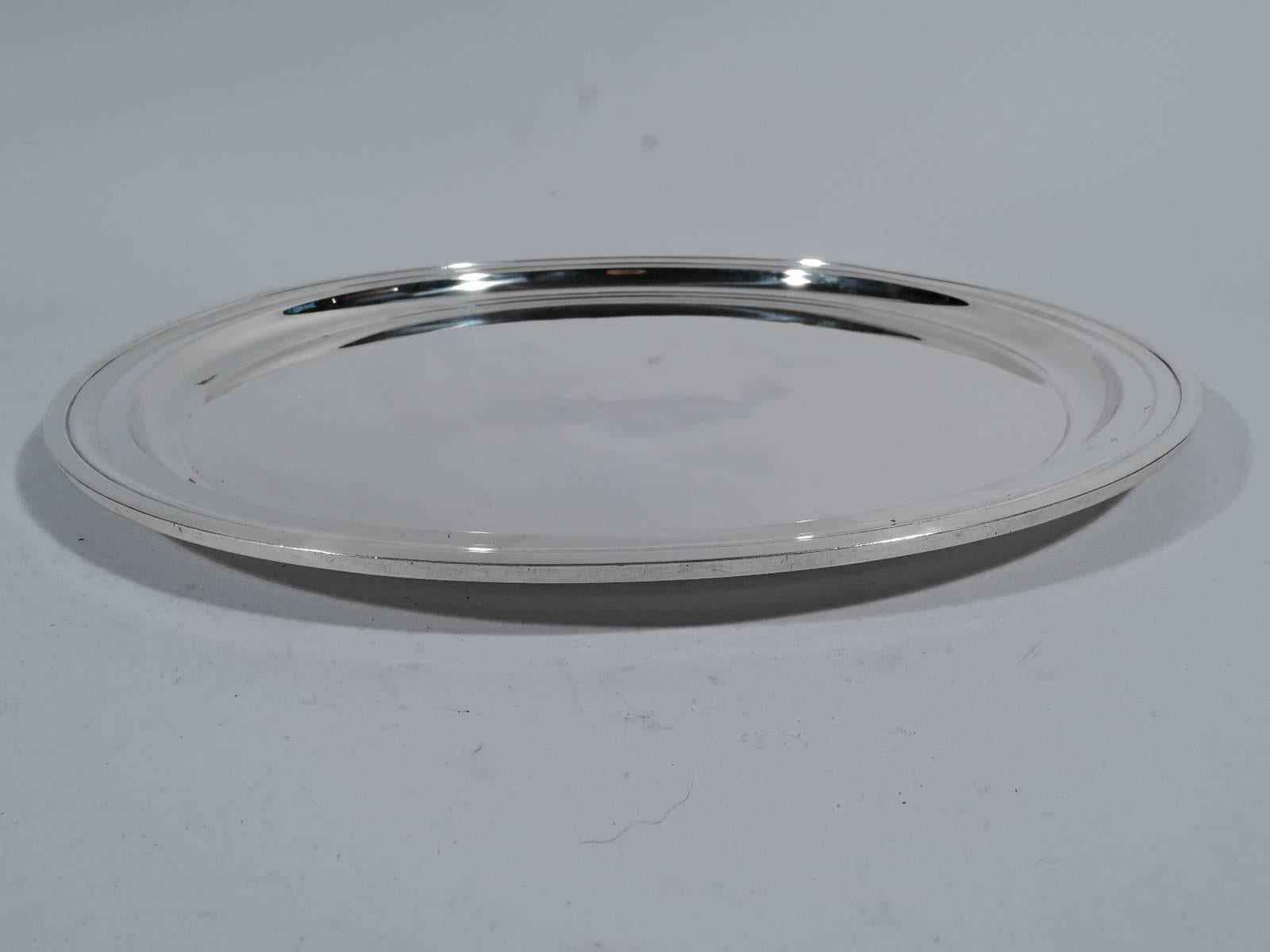 Modern sterling silver serving tray. Made by Tiffany & Co. in New York, circa 1928. Circular with well and molded rim. Hallmark includes pattern no. 21253 (first produced in 1928) and director’s letter m (1907-47). Measure: Weight 19 troy ounces.