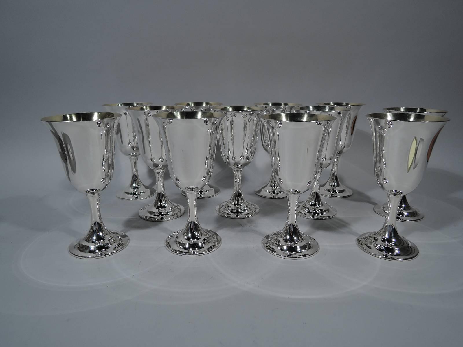 Set of 12 sterling silver goblets in Lord Saybrook pattern. Made by International Silver Co. in Meriden, Conn. Each: Tapering bowl with flared rim, upward tapering stem, and stepped foot. Bowl interior gilt. Hallmark includes pattern name and no.