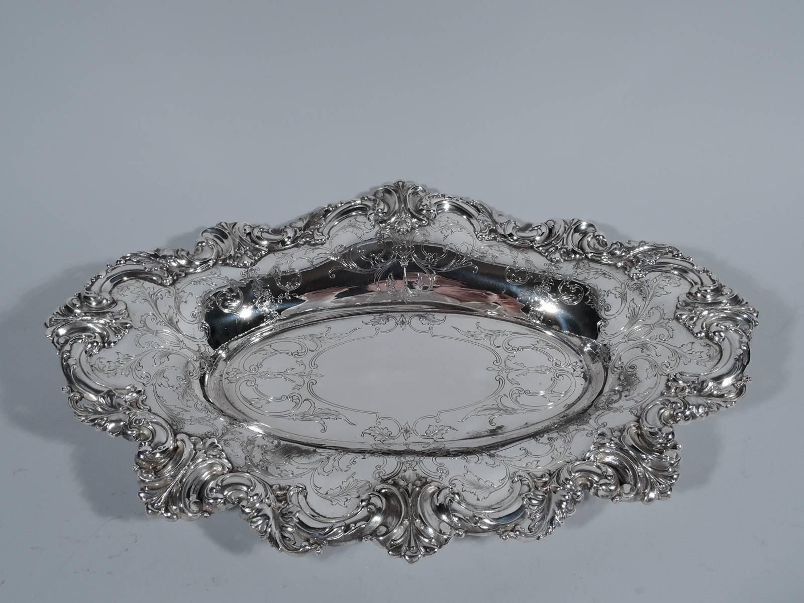 Beautiful and sumptuous sterling silver bread tray. Made by Shreve & Co. in San Francisco, circa 1900. Oval well with wavy rim. Engraved scrolls, flowers, and foliage. Substantial leaves and scrolls applied to rim. Hallmarked. Extra heavy weight: