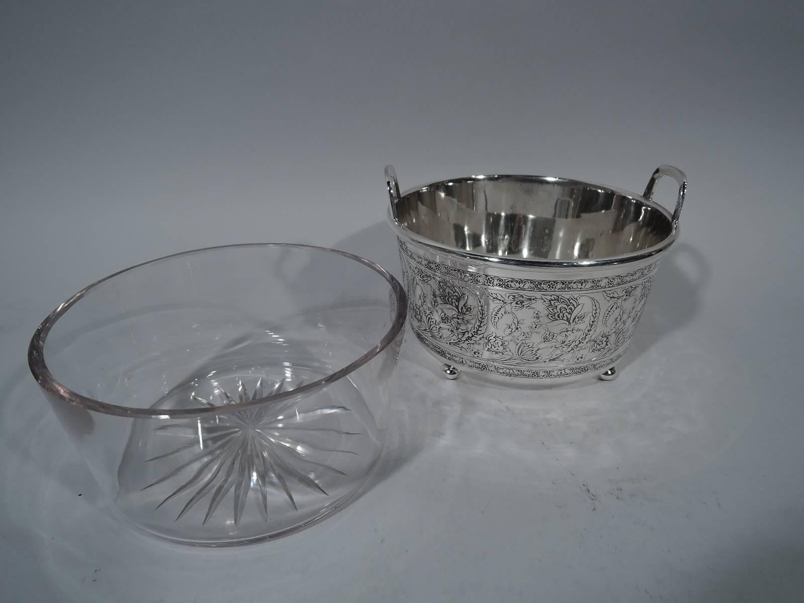 Art Nouveau sterling silver ice bucket. Made by Tiffany & Co. in New York, circa 1908. Straight and tapering sides, rim-mounted bracket handles, and four ball supports. Exterior has acid-etched scrolling and intertwining flora between