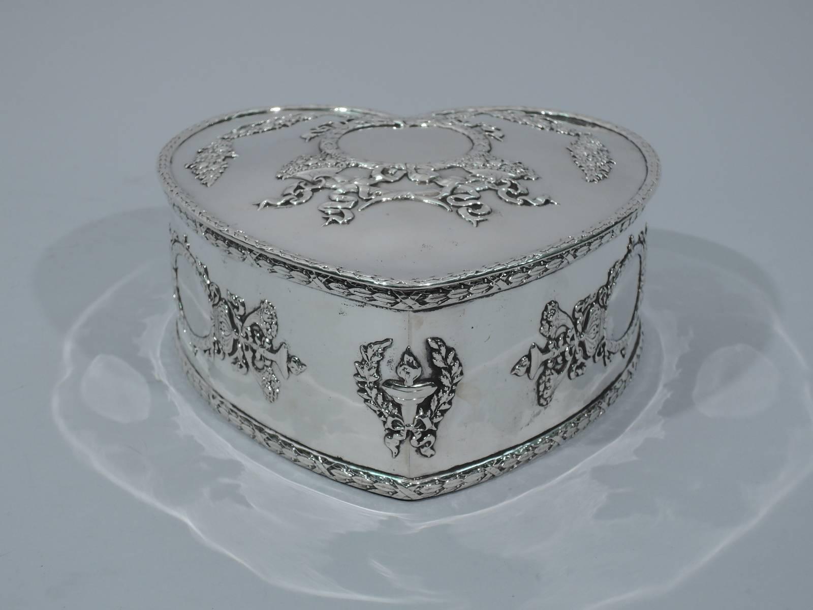 Regal and romantic sterling silver heart box. Made by Howard in New York in 1897. Heart form with hinged cover. Ornament includes garlands and ribbon applied to sides and cover. Also, three crowned cartouches (vacant). Hallmark includes date and