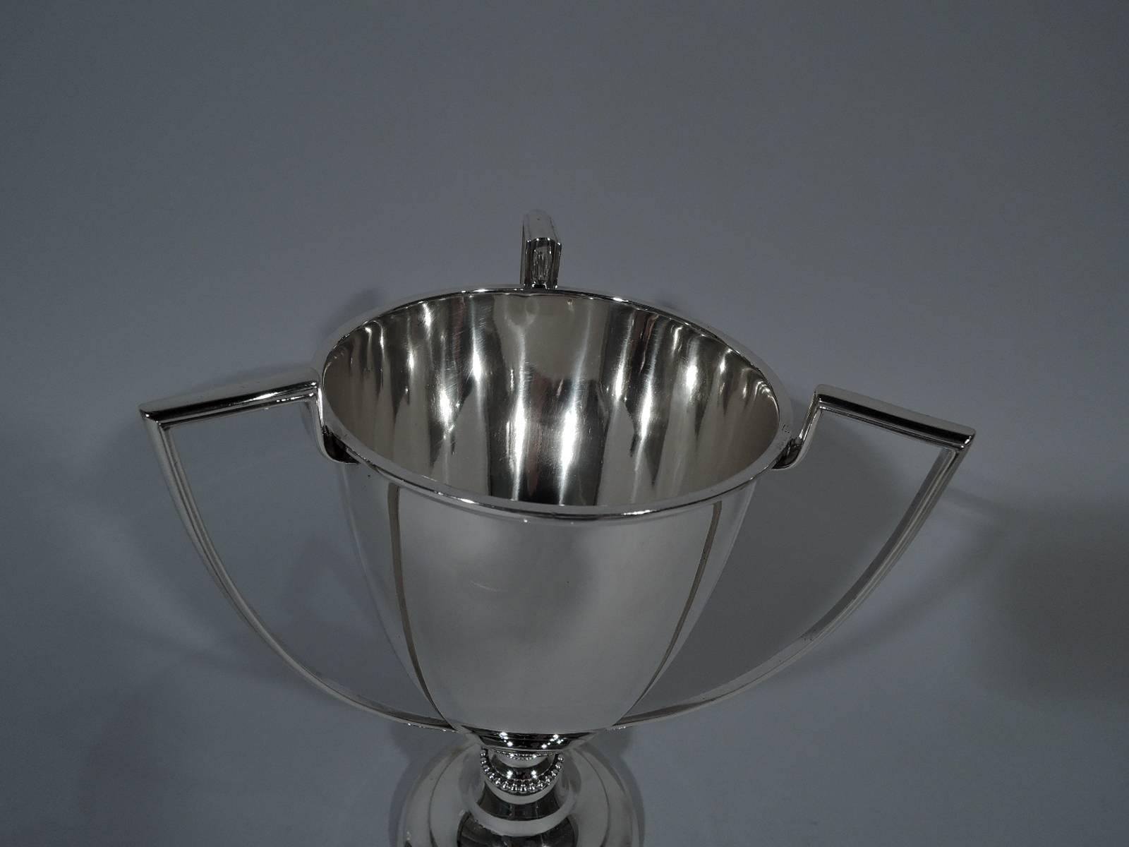 Sterling silver loving cup. Made by Whiting in New York, circa 1910. Tapering bowl with three scrolled bracket handles. Domed foot with beaded knop. A fine traditional form with plenty of room for engraving. Holds 1 1/2 pints. Hallmark includes no.