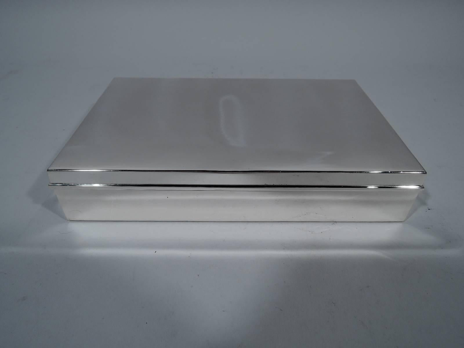 Classic sterling silver desk box. Made by Tiffany in New York, circa 1945. Rectangular with straight sides. Cover flat and hinged with molded rim. Hallmark includes pattern no. 22358, director’s letter m (1907-1947), and wartime star (1943-1945).