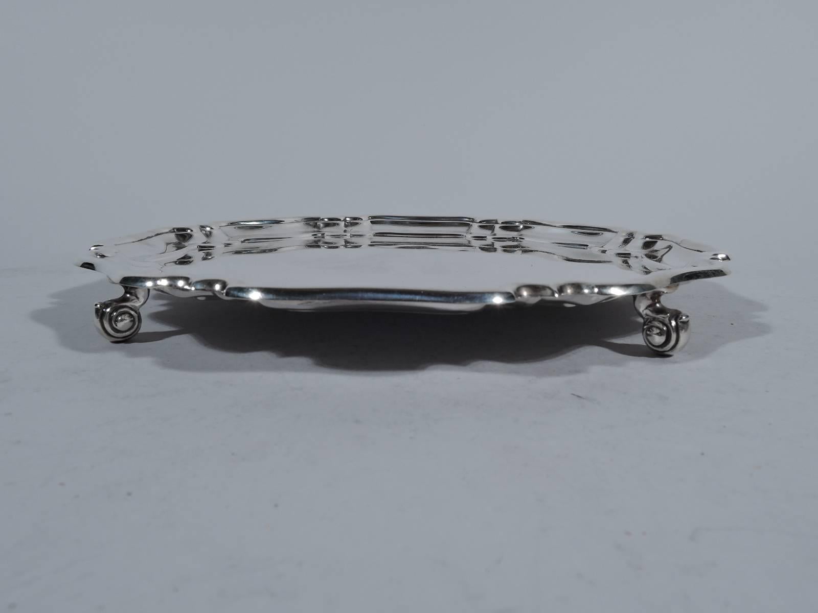 Georgian-style sterling silver salver. Made by Atkin Brothers in Sheffield in 1955. Circular with molded piecrust rim comprising alternating double C-scrolls and single wide scroll. Rests on four volute scrolls. Fully hallmarked including