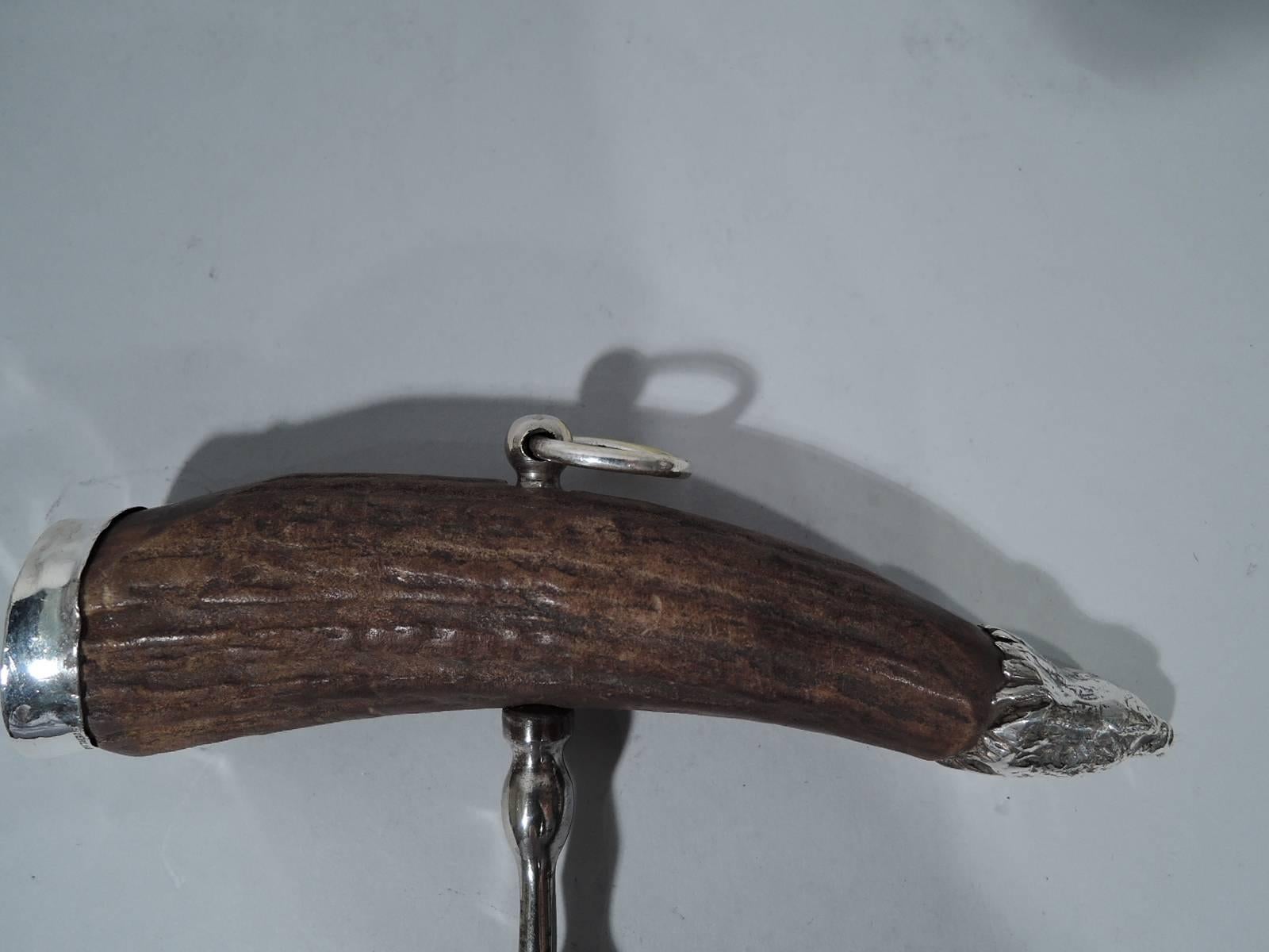American sterling silver corkscrew, circa 1910. Stag’s horn handle with sterling silver mounts. Front mount vacant. Back mount in form of eagle’s head. Loose-mounted ring on top. Hallmarked “sterling”.