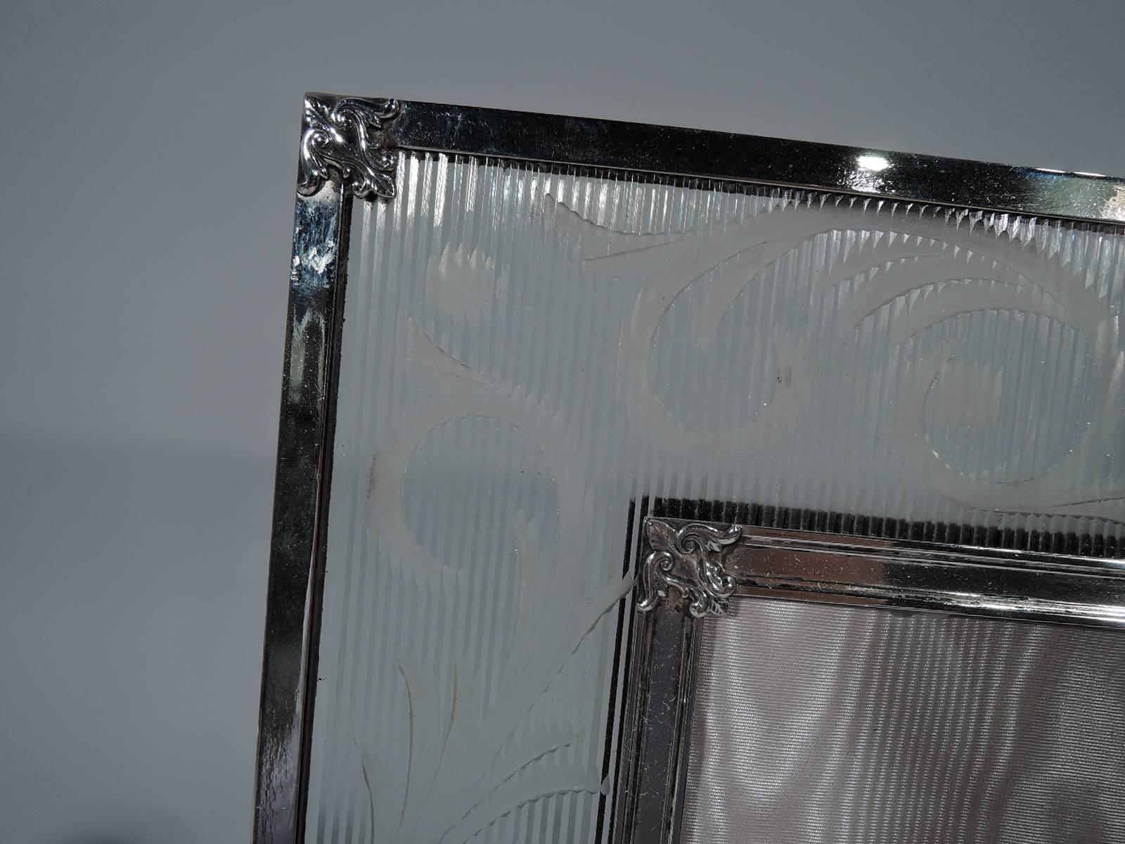 Beautiful Edwardian sterling silver and glass picture frame. Made by T. G. Hawkes in Corning, New York, circa 1915. Rectangular window with wide glass surround. Glass has vertical ribbing with etched scrollwork and plain ovals with etched garlands