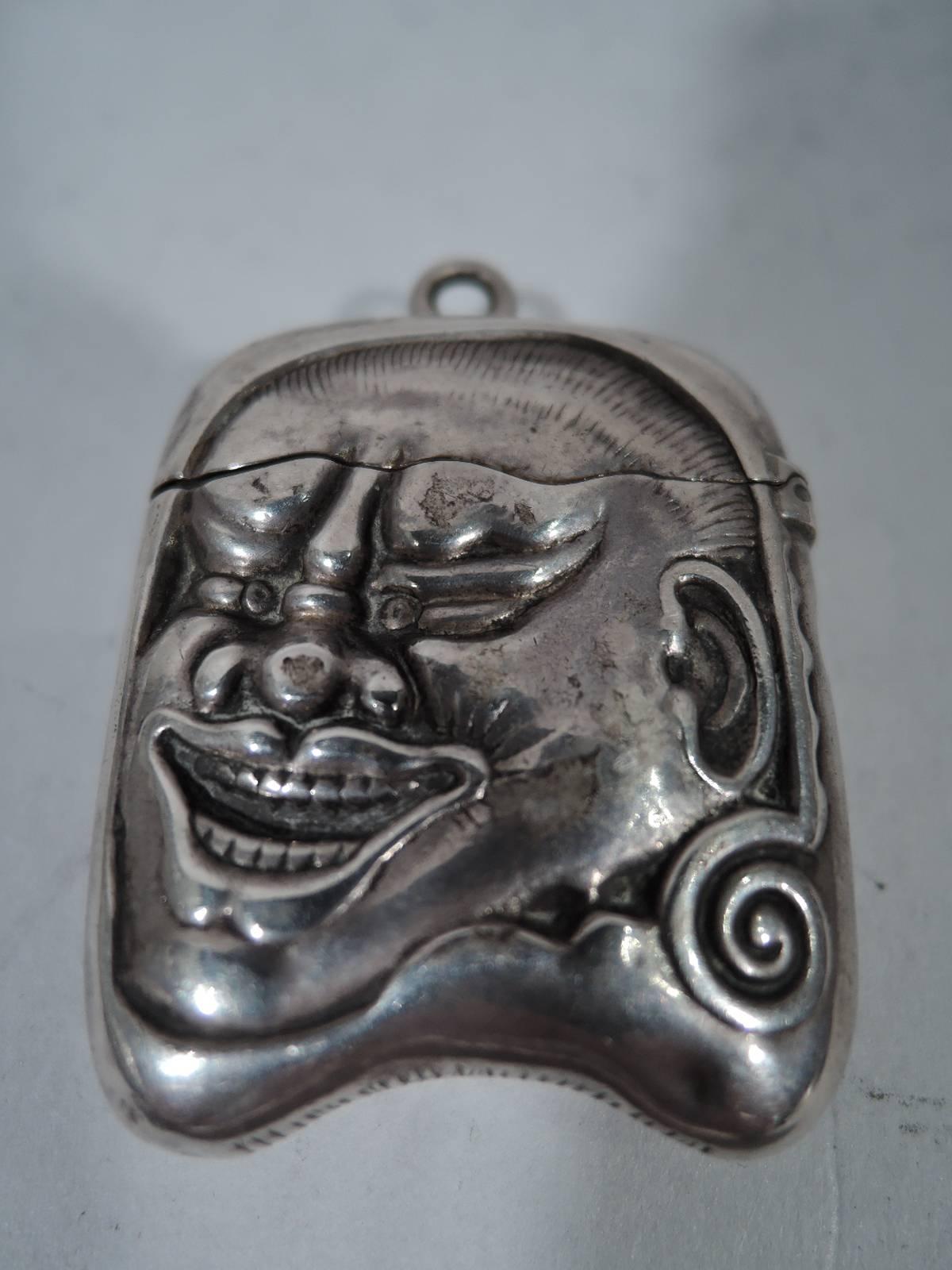 Exotic sterling silver match safe. Made by Gorham in Providence in 1884. Hinged cover has ring and underside strike. On front and back is a head of a Japanese oni, a folkloric figure. Hallmark includes no. 390 and Japanese date letter.