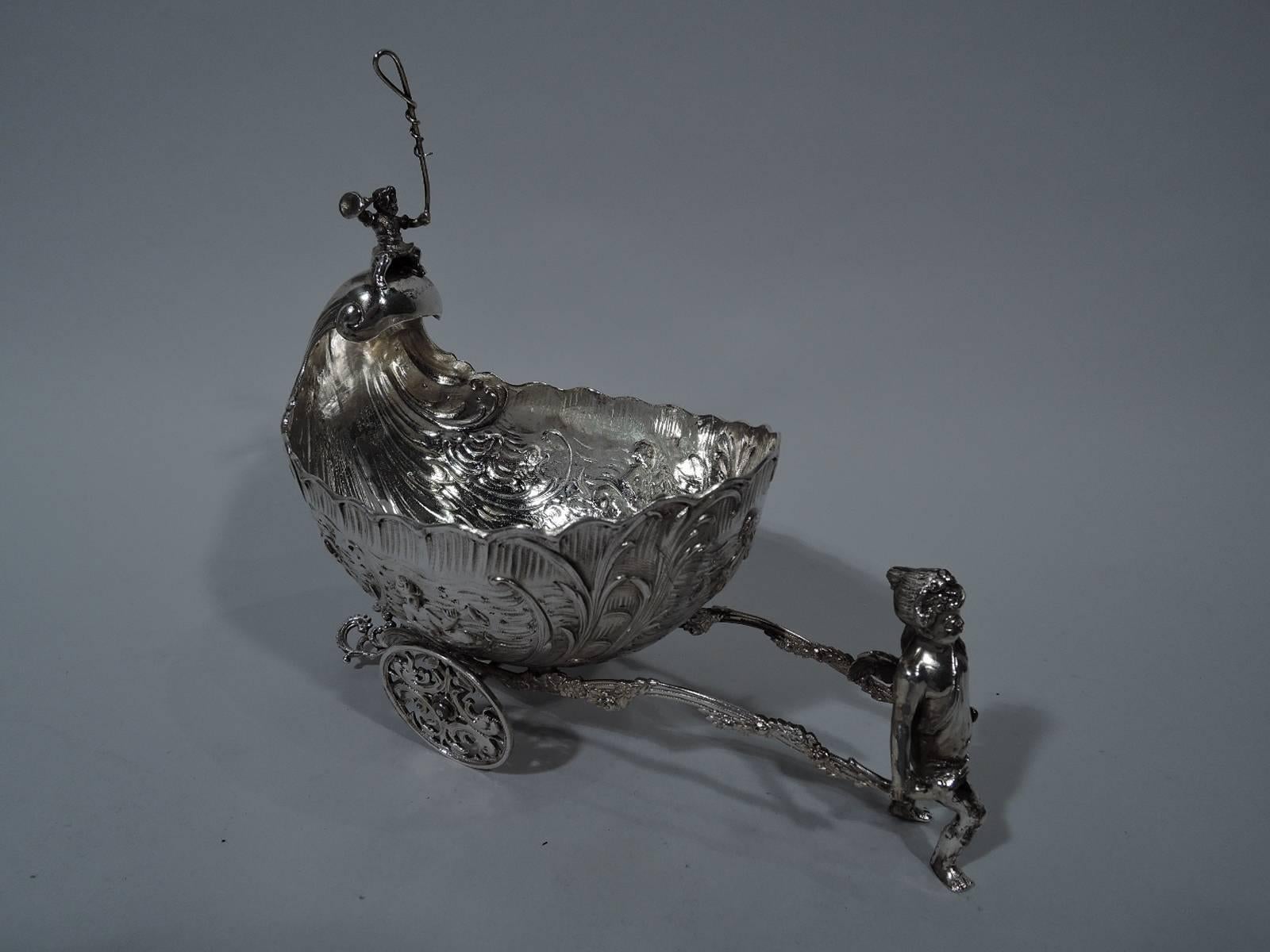 Antique German 800 silver love chariot. The vehicle is decorated with cherubic Neptunes frolicking in the water. It has a wavy rim and rising spiral on which is mounted an infant postilion with bugle and whip (!), and is harnessed to a winged cupid