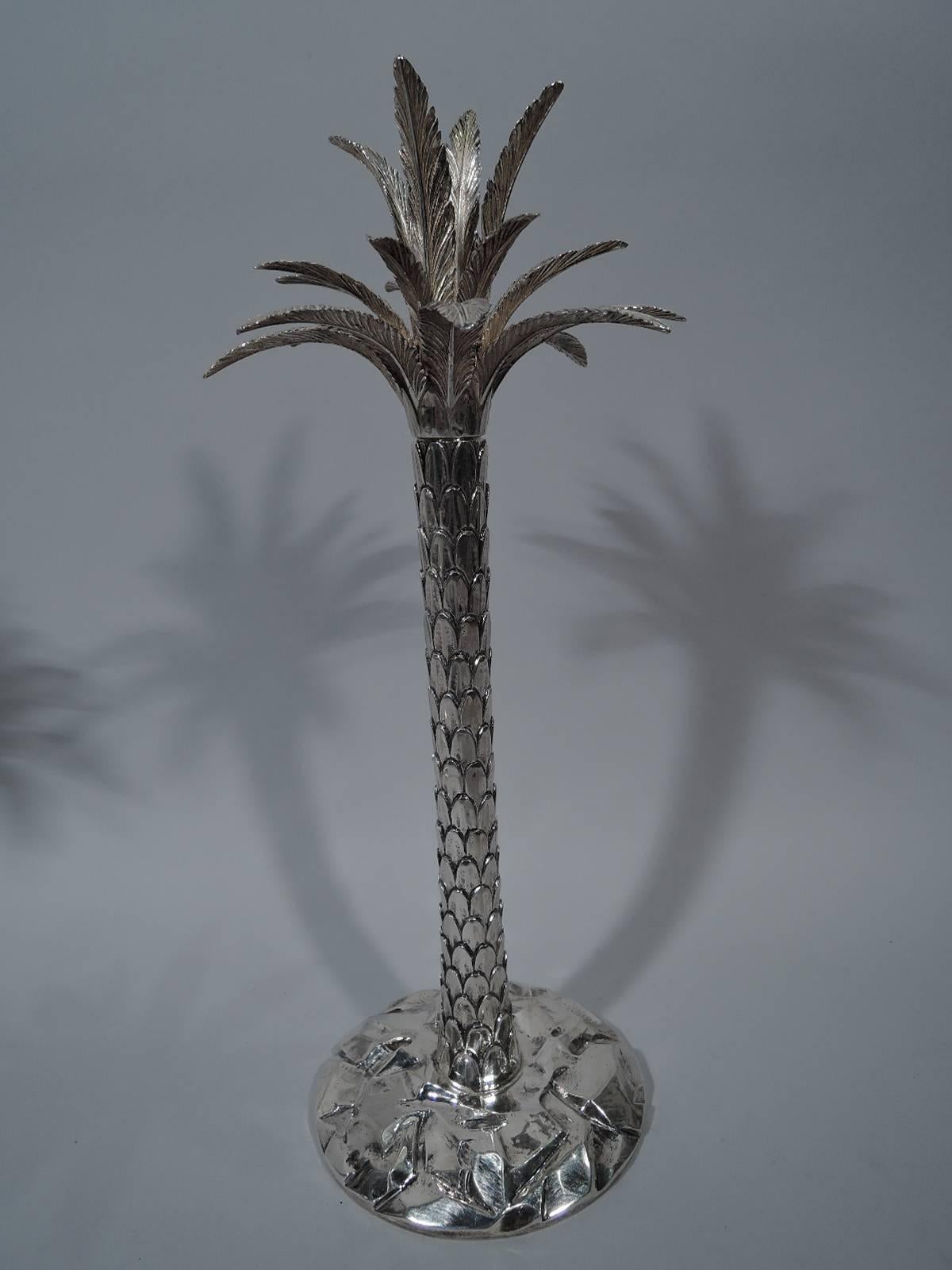 Pair of fabulous sterling silver palm tree candlesticks. Retailed by Tiffany in New York. Each: Columnar trunk with imbricated bark rooted to uneven terrain (that is, a round base). Socket concealed amidst dense fronds. A 1960s tiki-era motif that