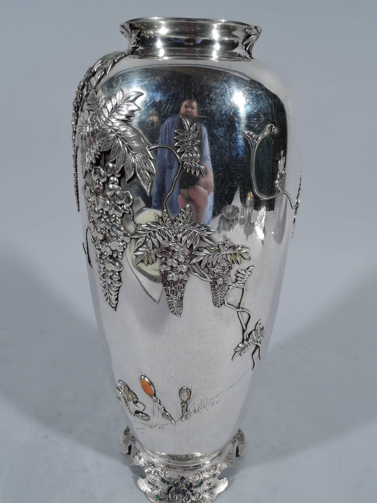 Japanese Meiji silver and enamel vase. Curved and tapering body with inset mouth and raised and spread foot. Applied ornament heightened with enamel: Blossoming wisteria branches as well as scattered flowers rooted in engraved grass. A lone bird