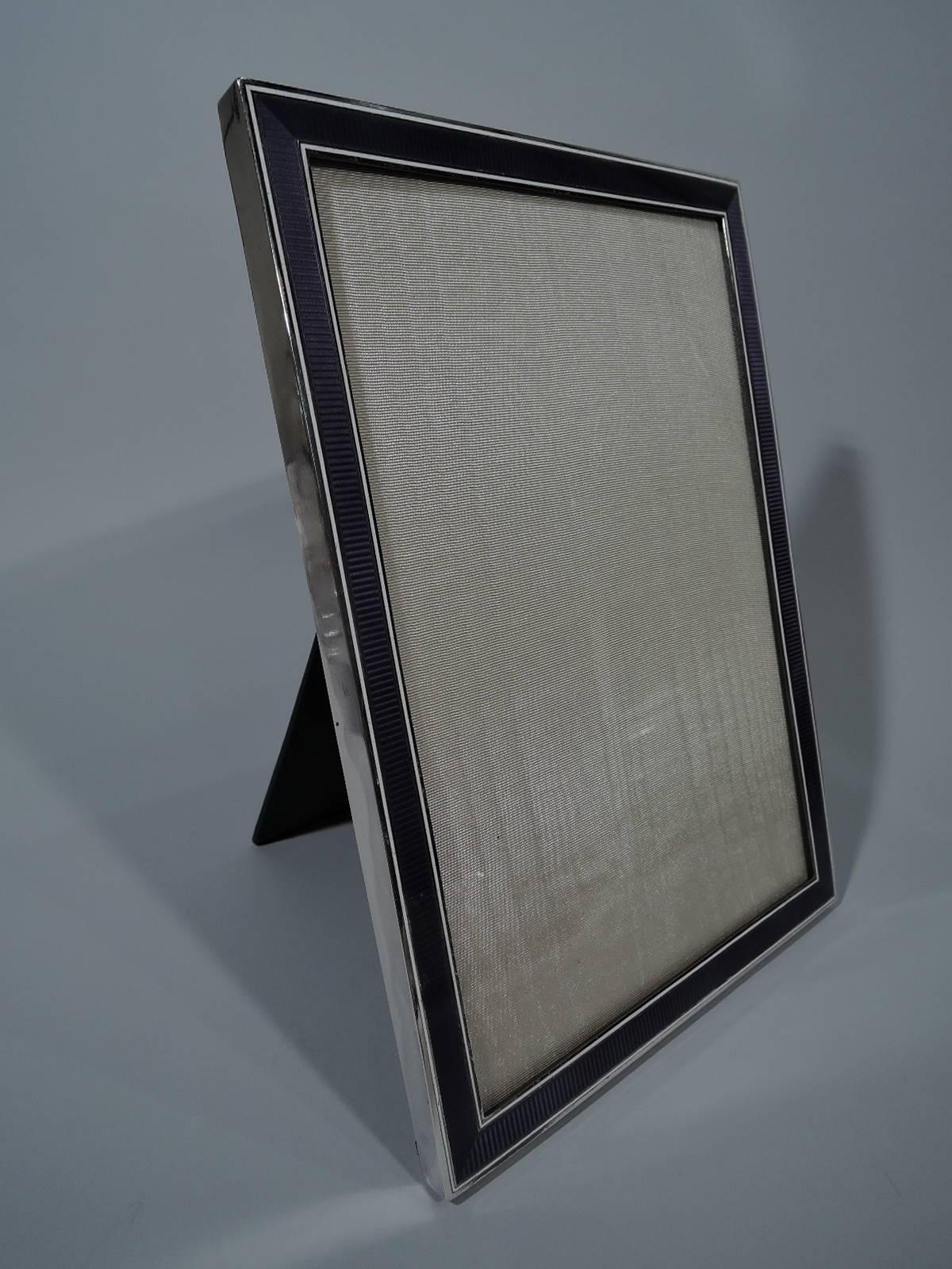 Art Deco 950 silver and enamel picture frame, circa 1920. Rectangular window and purple enameled ribbing between white lines. With glass, silk lining, and leather back and hinged support. A distinctive design for a very special picture. French