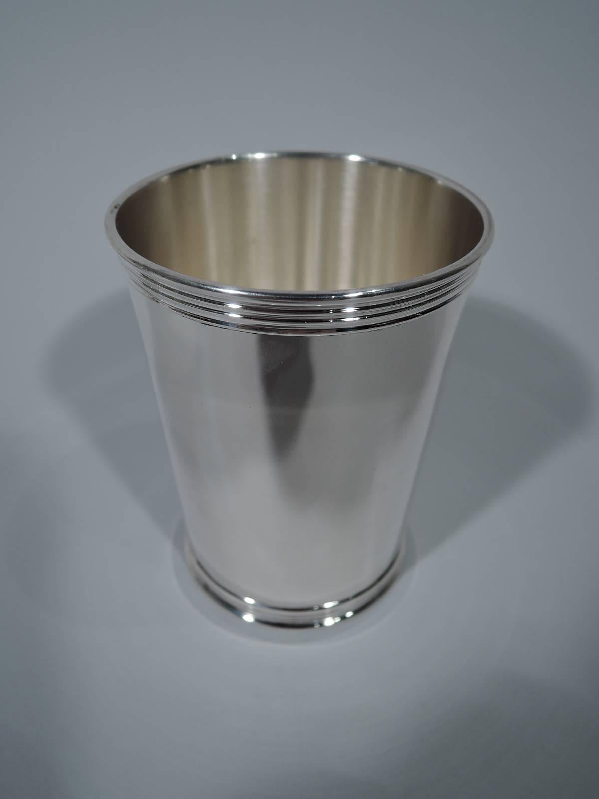 Pair of American sterling silver mint julep cups. Each: Straight and tapering sides and reeded rim and foot. Hallmark includes retailer’s name W. Bell & Co. Total weight: 8.4 troy ounces.