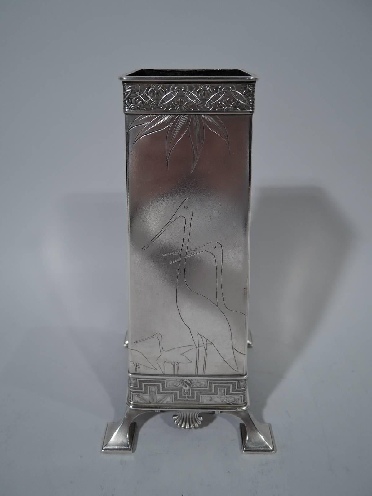 Early sterling silver Japonesque vase. Made by Tiffany & Co. in New York. Four straight and upward tapering sides and splayed block corner supports. Engraved bamboo, cranes, blossoming prunus branch, and kimono-clad figure holding fan and fish.