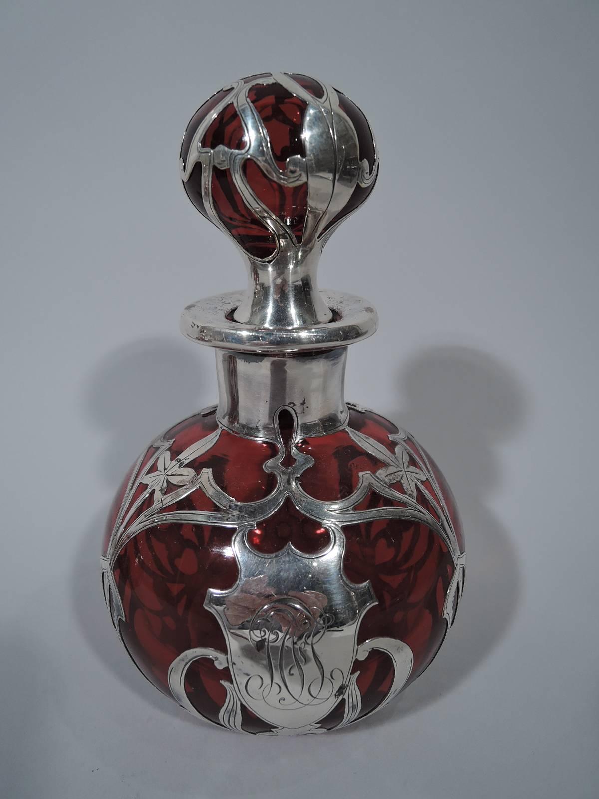 Pair of red glass perfumes with silver overlay. Made by Gorham in Providence, circa 1900. Each: Globular with short neck and everted rim. Ball stopper with short plug. Repeating overlay pattern with whiplash lines and scrolls as well as stylized