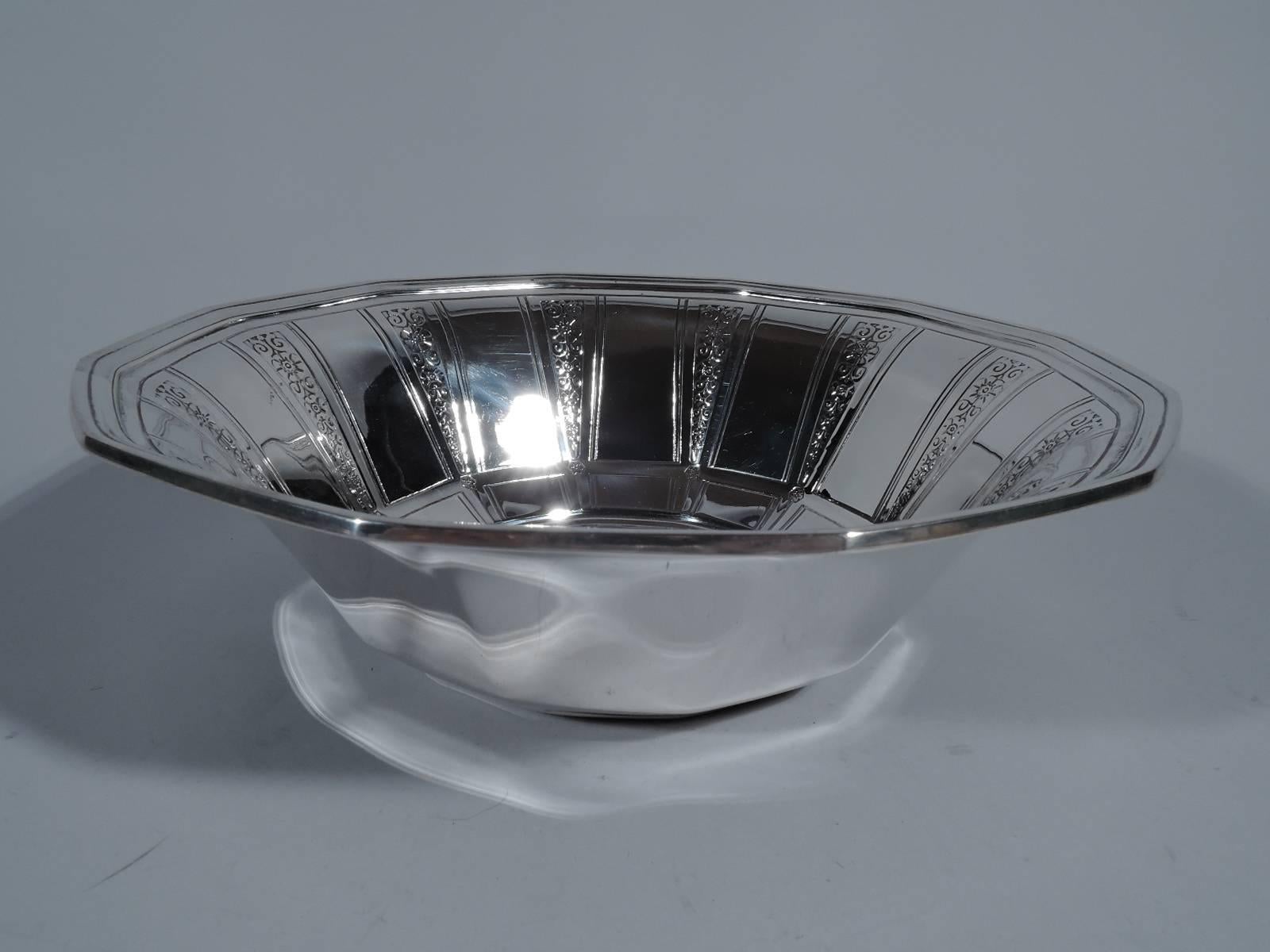 Art Deco sterling silver bowl. Made by Tiffany & Co. in New York, ca 1924. Tapering and faceted sides with molded rim. Interior has alternating engraved pilasters and acid-etched triangles with stylized flowers and scrolls. Hallmark includes pattern