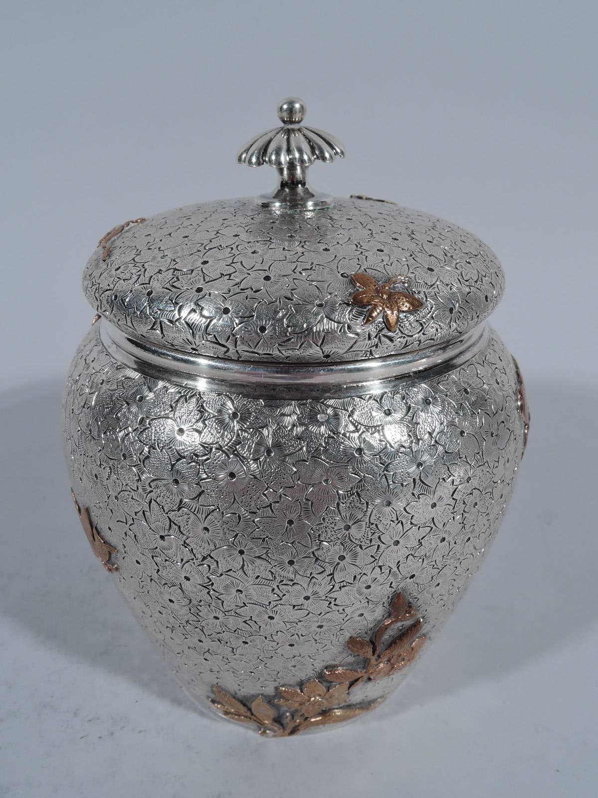 Unusual sterling silver and mixed metal tea caddy. Made by Dominick & Haff in New York in 1880. Ovoid with bun cover and lobed finial. Engraved and stippled floral ground with copper and gold appliques: butterflies, bird, lizard, grain heads,