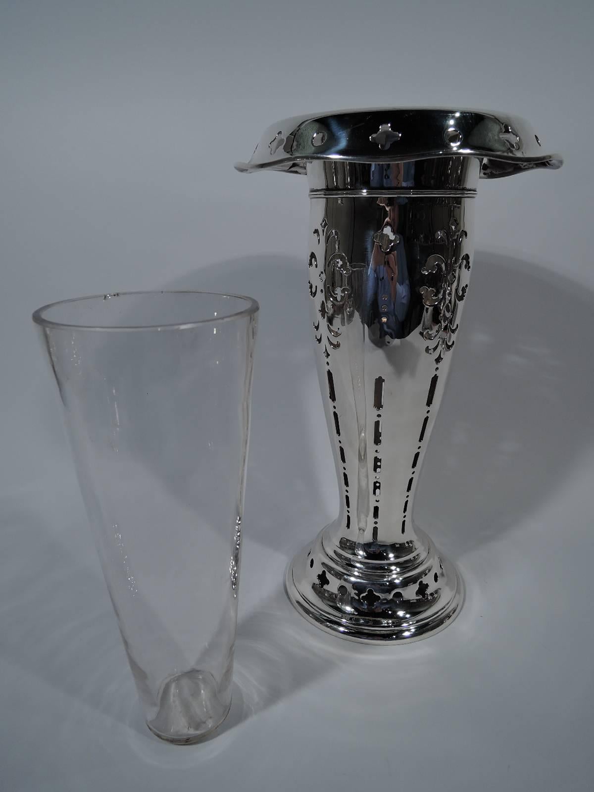 Substantial sterling silver vase. Made by Tiffany & Co. in New York, circa 1903. Tapering sides, turned-down and wavy rim, and domed foot. Pierced and stylized leaves, flowers, circles and quatrefoils. Clear glass liner. Hallmark includes pattern