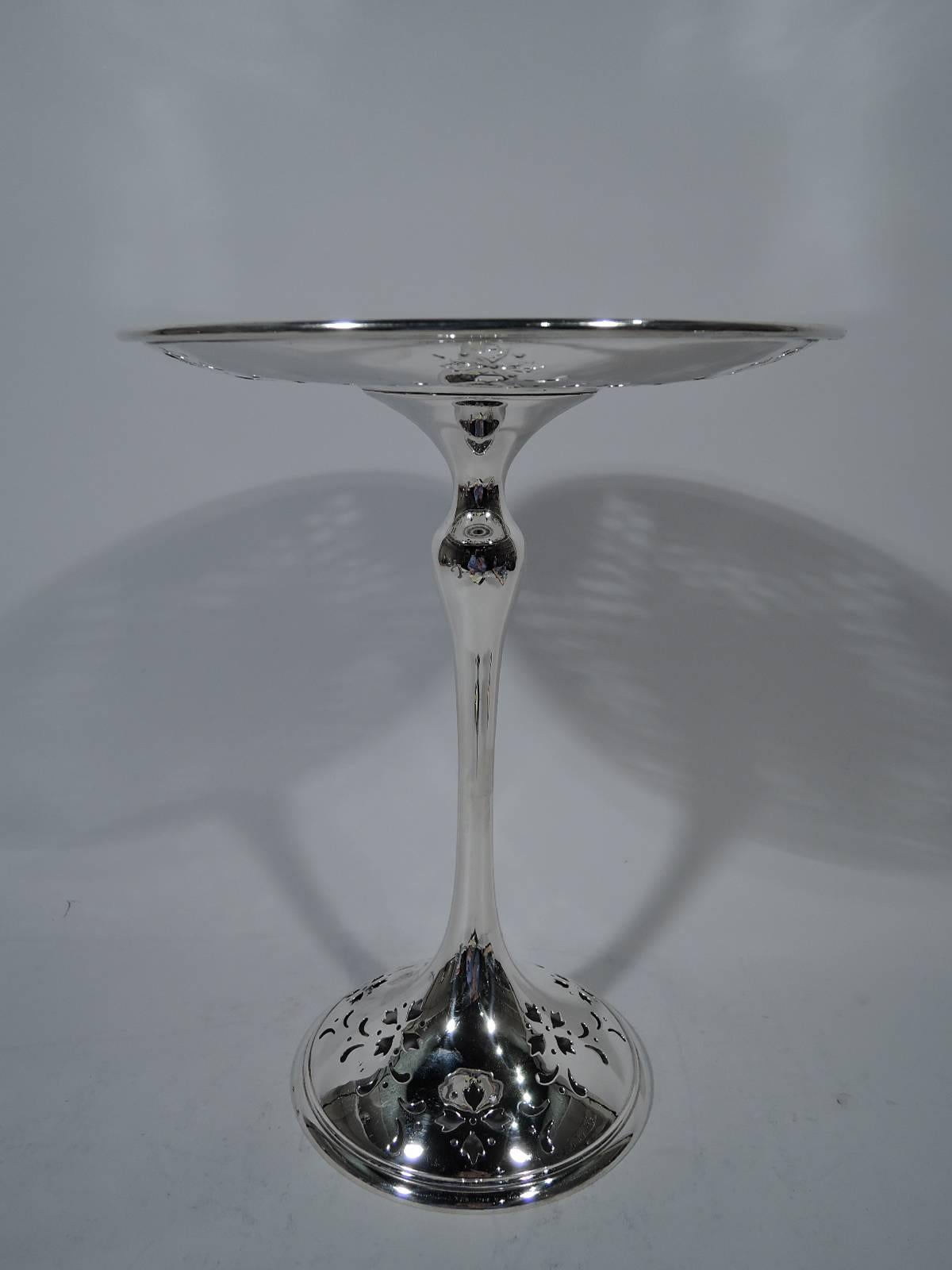 Tall Edwardian sterling silver compote. Made by Shreve & Co. in San Francisco, circa 1920. Shallow bowl with plain and inset well surrounded by wide rim. Slender baluster shaft and domed foot. Pierced and stylized garlands on bowl and foot.