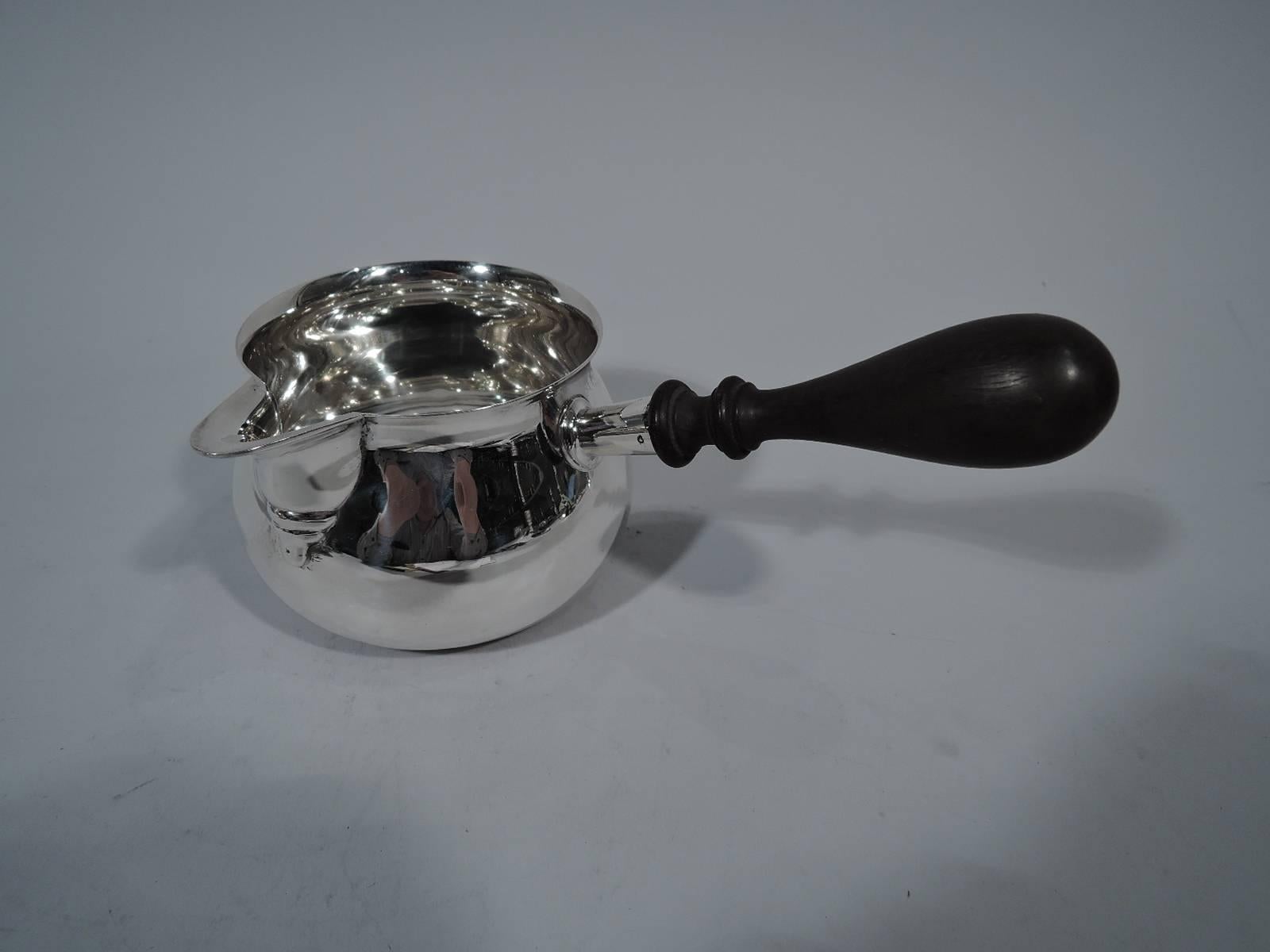 Large sterling silver pipkin. Retailed by Tiffany & Co. in New York. Round bowl with v-spout and tapering stained-wood baluster handle. A nice piece in this size. Hallmarked. Gross weight: 9.8 troy ounces.