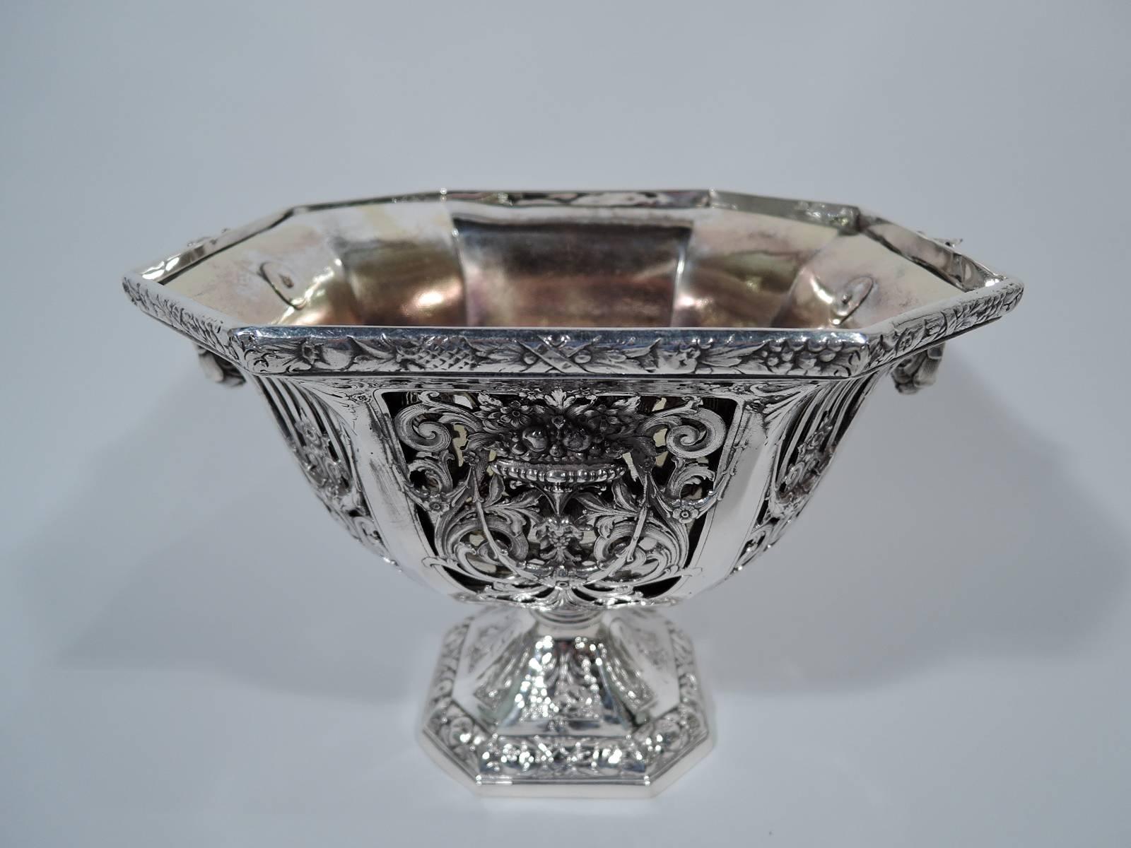 Sumptuous sterling silver jardinière. Retailed by Bailey, Banks & Biddle in Philadelphia. Square rim with chamfered corners, curved sides, and raised foot, which is also square and chamfered. Bowl has pierced scrollwork with applied flower baskets