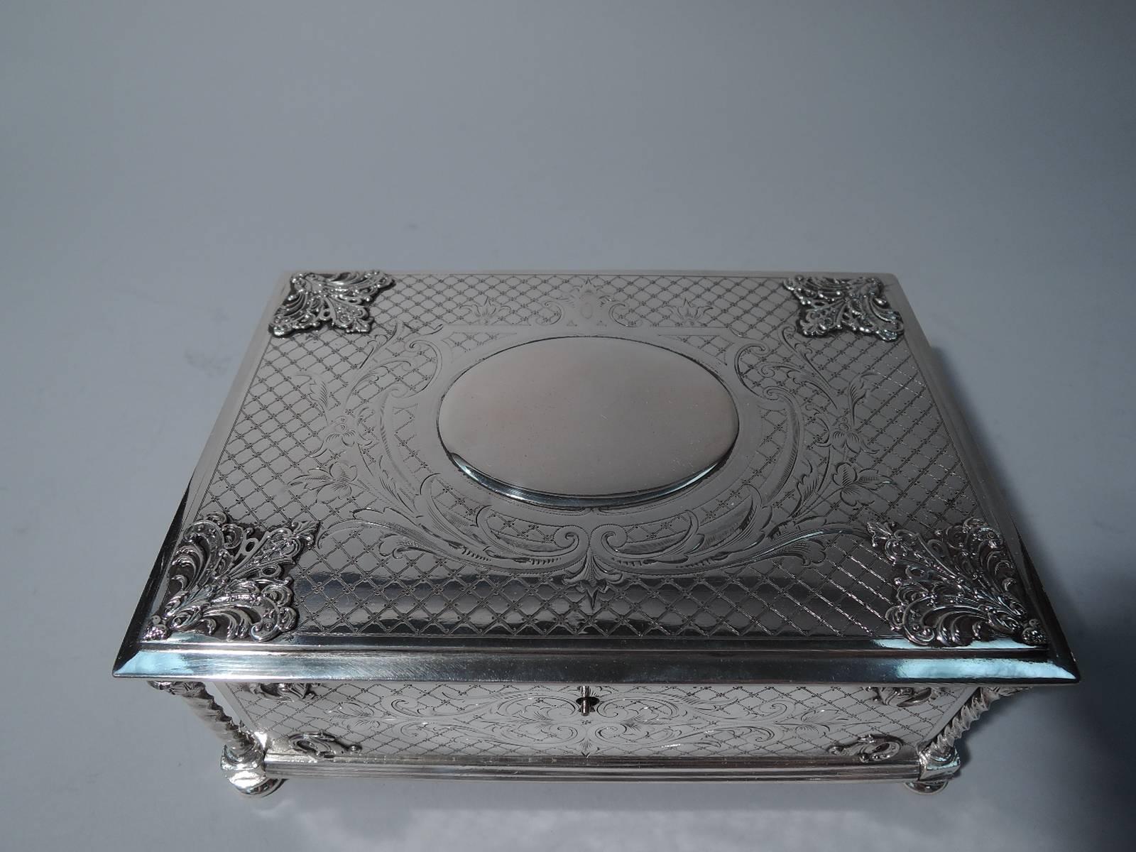 Austrian 800 silver box, circa 1880. Rectangular. Flat hinged cover, twisted corner columns with foliate capitals and applied foliage and scrolls. Engraved scrolls and foliage on diaper ground. Cover has applied oval cartouche (vacant). Rests on