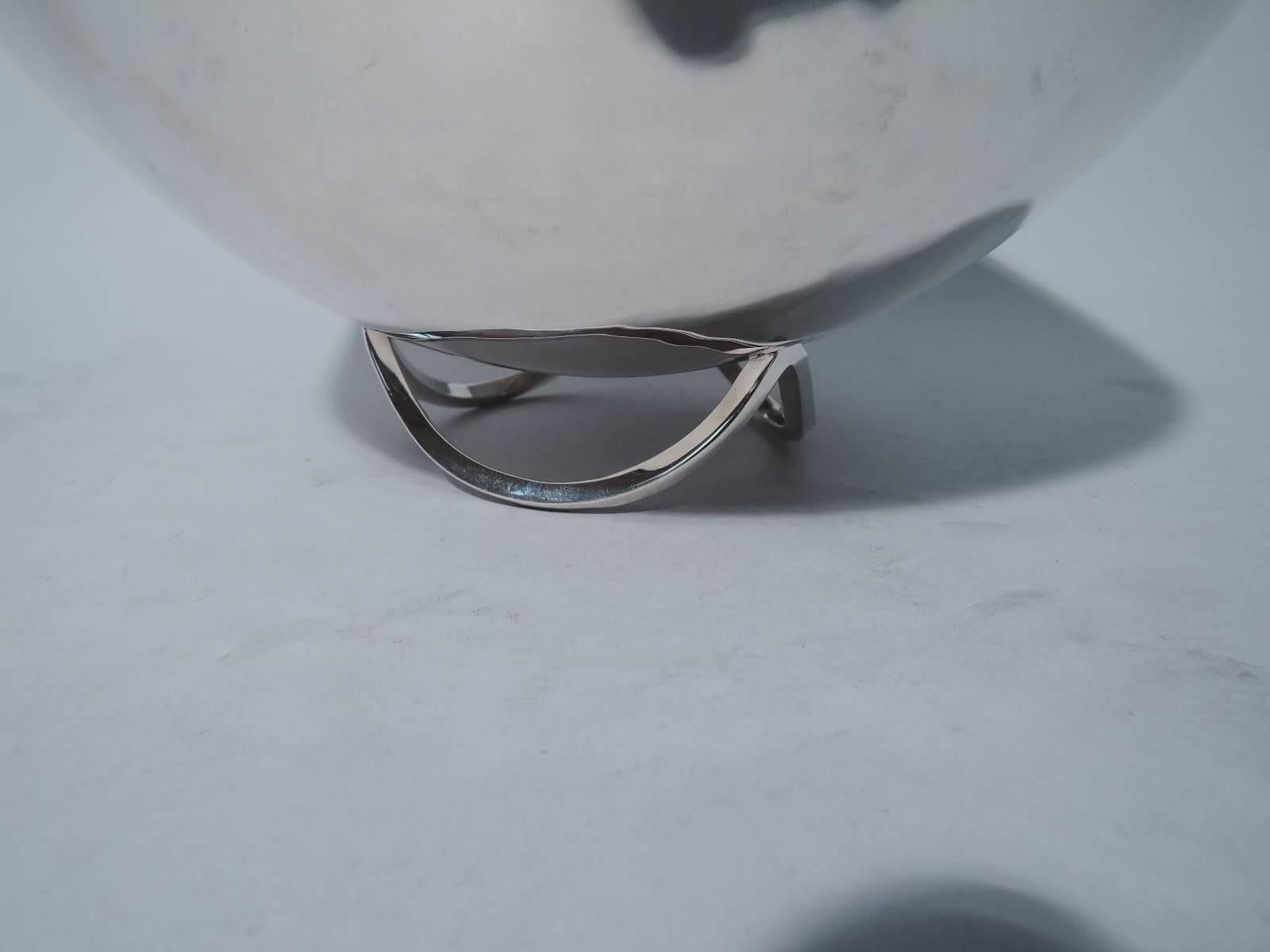Mid-Century Modern sterling silver bowl. Made by Cartier in New York. Hemispheric bowl mounted to base comprising 3 joined arches. Visible hand hammering. A gorgeous mix of craftsmanship and abstraction. Hallmark includes no. S104. Fine