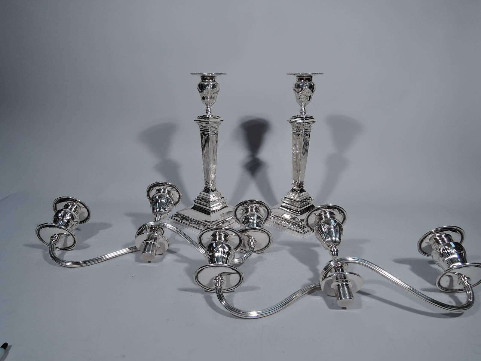 Pair of neoclassical sterling silver candelabra. Made by Tiffany & Co. in New York, circa 1913. Tapering and reeded pillar on stepped square base. Central light with wraparound reeded arms, each terminating in single light. Sockets urn-form with