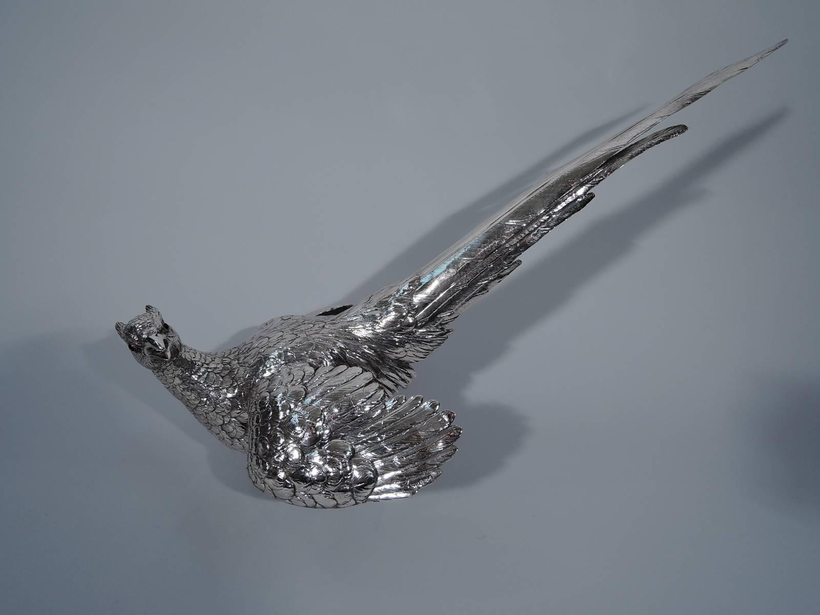 Pair of sterling silver pheasants. Imported to London by JMR in 1964. The two birds appear startled. The male turns his head and flexes his wings. The female has her wings raised for flight. Fine delineation of the feathers and scaly talons as well