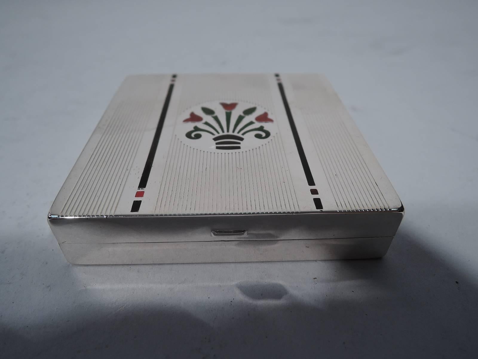 Sterling silver and enamel box. Made by Tiffany & Co. in New York, circa 1950. Square with hinged cover. Cover and underside have vertical reeding. Cover also has ornament in red, green, and black enamel: central circular frame with stylized