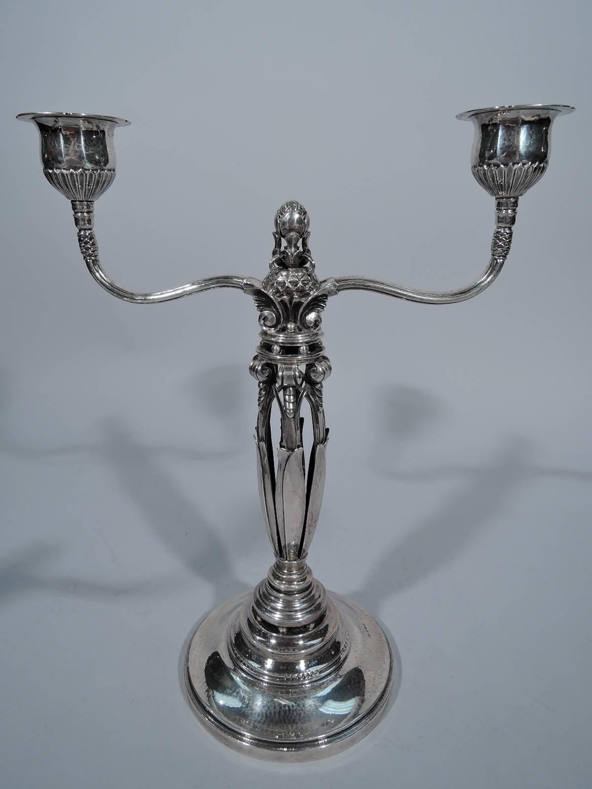 Pair of sterling silver two-light candelabra. Designed by Johan Rohde for Georg Jensen in Copenhagen. Each: Open leaf shaft surrounding pistil and mounted to stepped round base. At shaft top are scrolls with scales mounted to interlacing arcade.