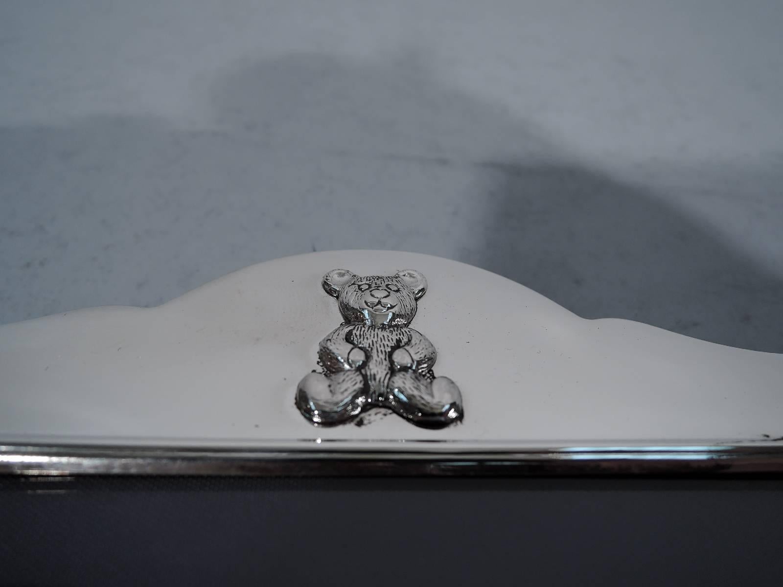Sterling silver picture frame. Made by Carr’s of Sheffield in 1997. Vertical rectangular window with straight borders and arched top with applied teddy bear – a sweet beast with stubby limbs and alert ears. A great baby gift. With glass, silk