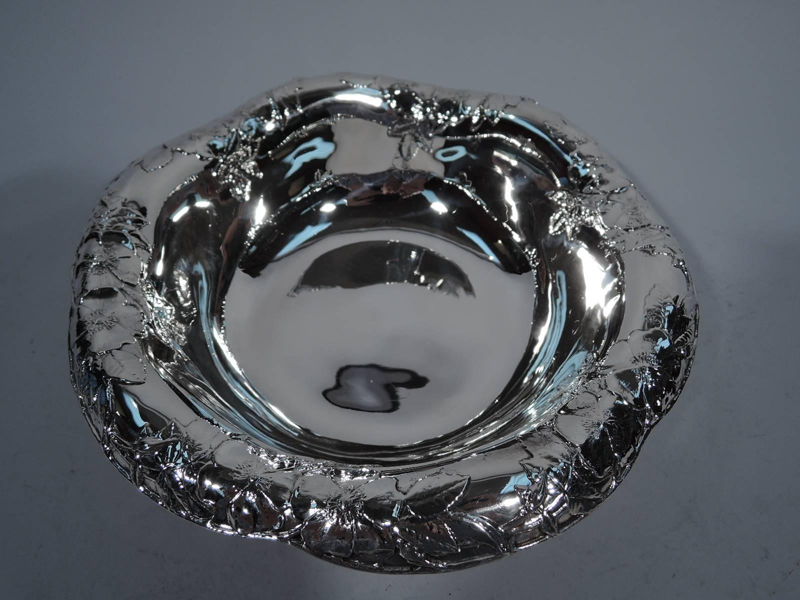 Sterling silver bowl. Made by Tiffany & Co. in New York, circa 1907. Curved sides and wavy and scrolled turned-down rim with applied blossoms. Pretty. Hallmark includes pattern no. 16858E (first produced in 1907) and director's letter m (1907-47).