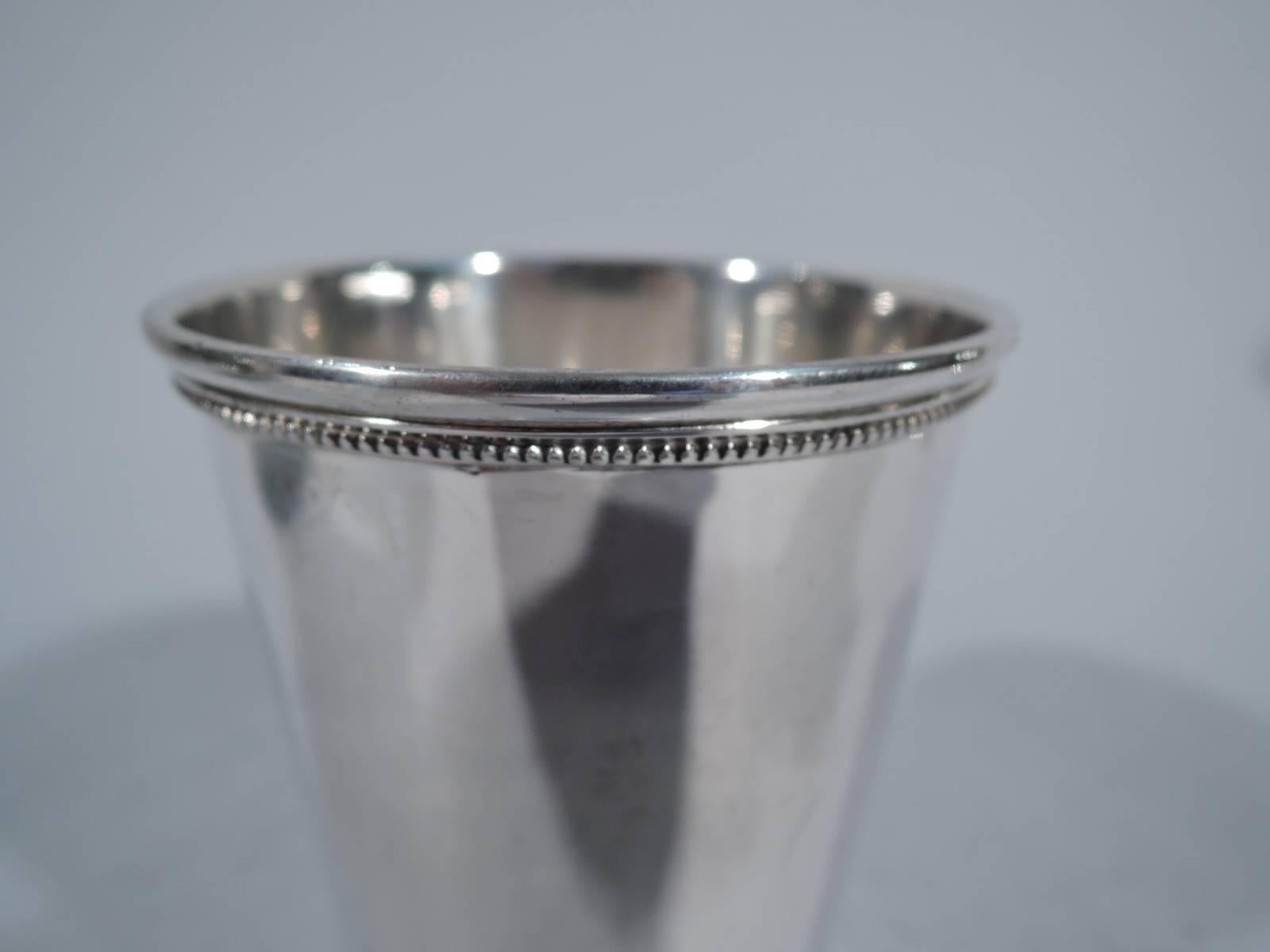 Sterling silver mint julep cup. Made by International in Meriden, Conn. Straight and tapering sides, molded and beaded rim, and beaded and spread foot. Hallmark includes name Patrick Henry and no. 103/25. Very good condition.

Dimensions: 4 1/8 x