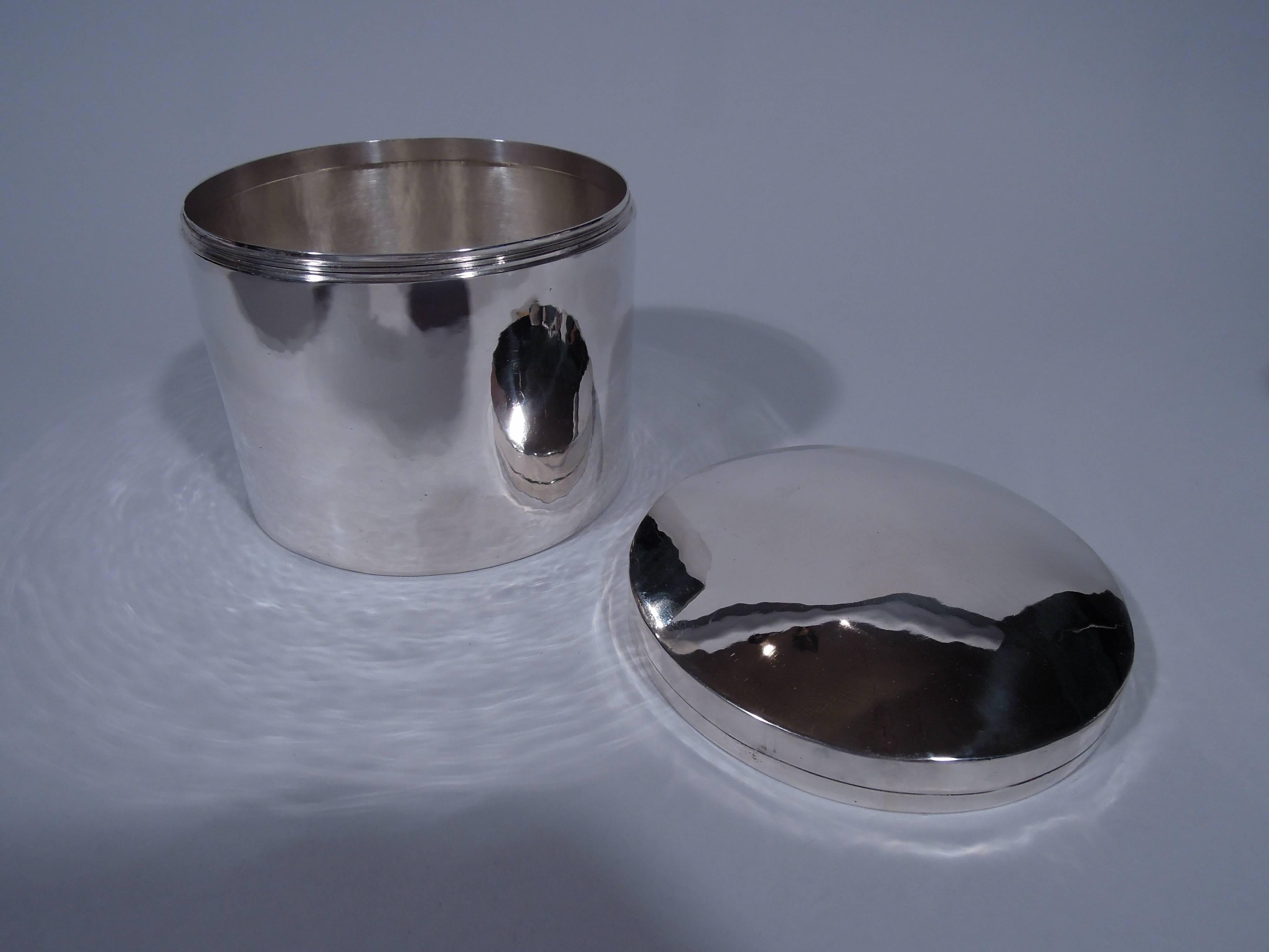 Sterling silver box. Made by Kalo Shop in Chicago, circa 1920. Drum-form with straight sides. Cover threaded and gently curved with incised rim band. A second band formed from cover and box seam. An economical design with fine hand-hammering. Enough