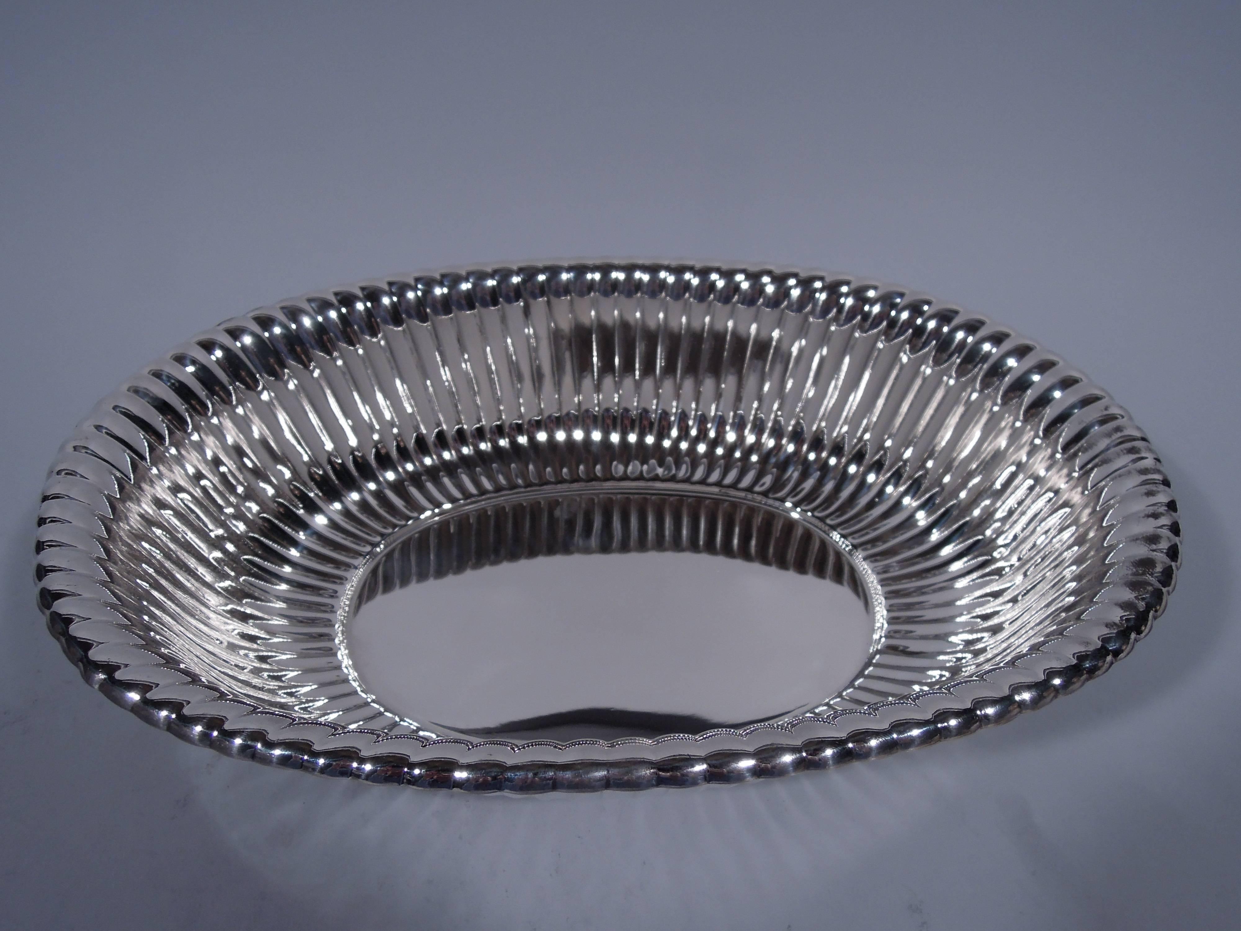 Modern sterling silver bowl. Made by Reed & Barton in Taunton, Massachusetts in 1948. Plain oval well, curved sides, flared rim and short foot. Sides exterior have slanted flutes. Dynamic and tactile. Hallmark includes date symbol and no. X369.
