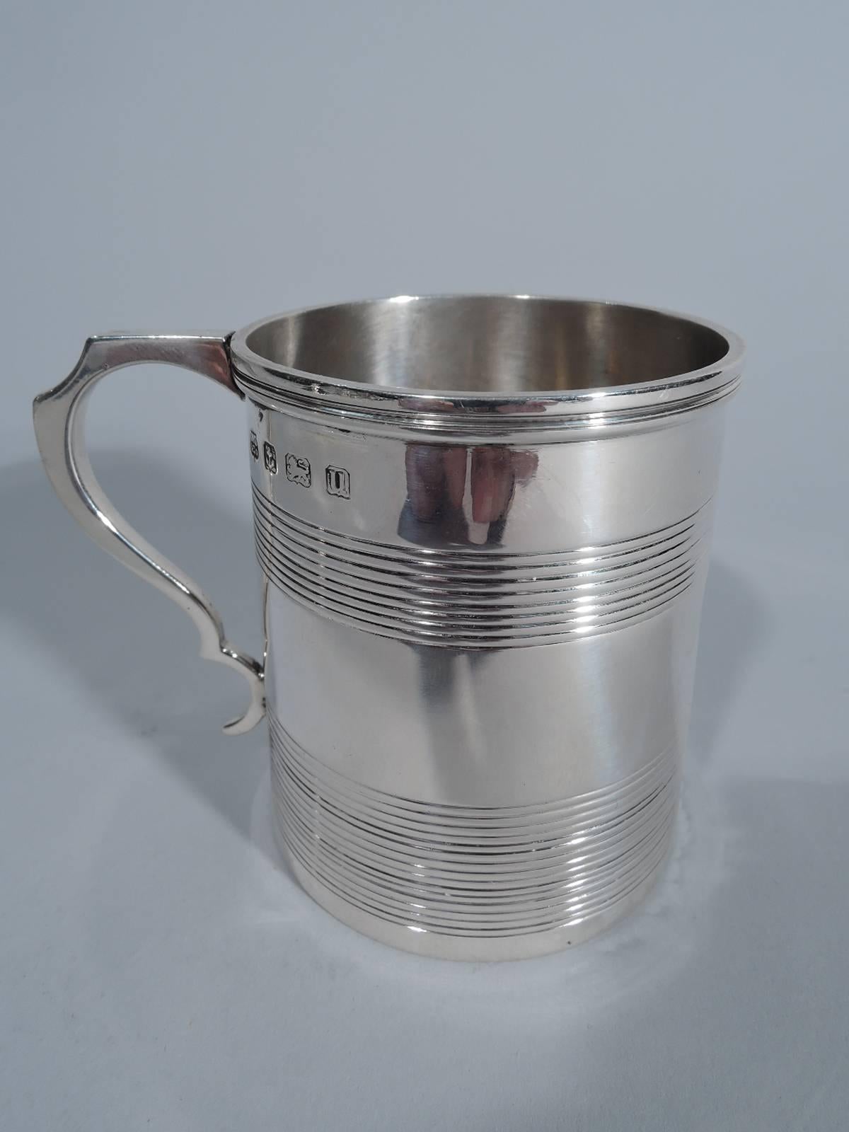 George V sterling silver baby cup. Made by Samuel Walton Smith in Birmingham in 1919. Straight and upward tapering sides, molded rim, and double-scroll handle. Plain with two reeded bands. Lots of room for engraving.

Dimensions: H 2 5/8 x W 3 1/8