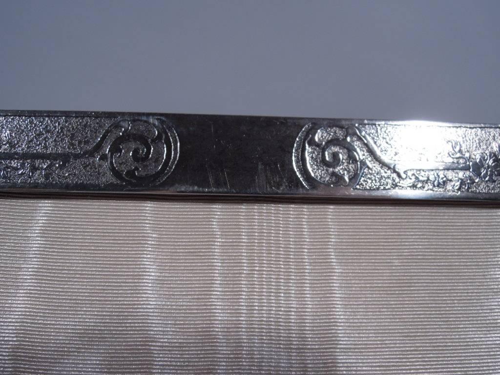 Rare Art Nouveau sterling silver picture frame. Made by Tiffany & Co. in New York. Rectangular and vertical window bordered by acid-etched scrolls and flowers on stippled ground. Vacant cartouche.

A controlled and spare design that shows off the