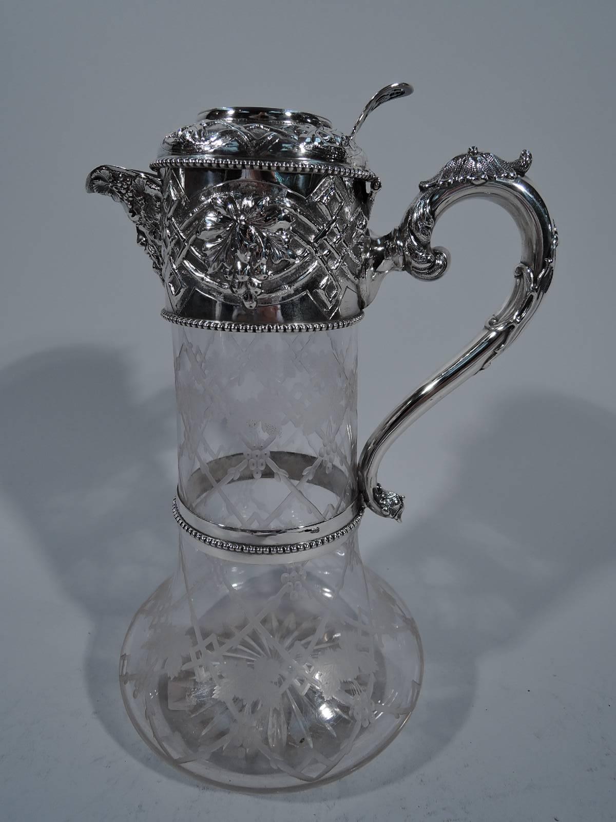 Victorian sterling silver and crystal wine decanter. Made by Walter and Charles Sissons in Sheffield in 1867. Cylindrical neck and squat and curved bottom. Acid etched trellis with fruiting grapevine. Silver collar, v-spout, hinged cover, and