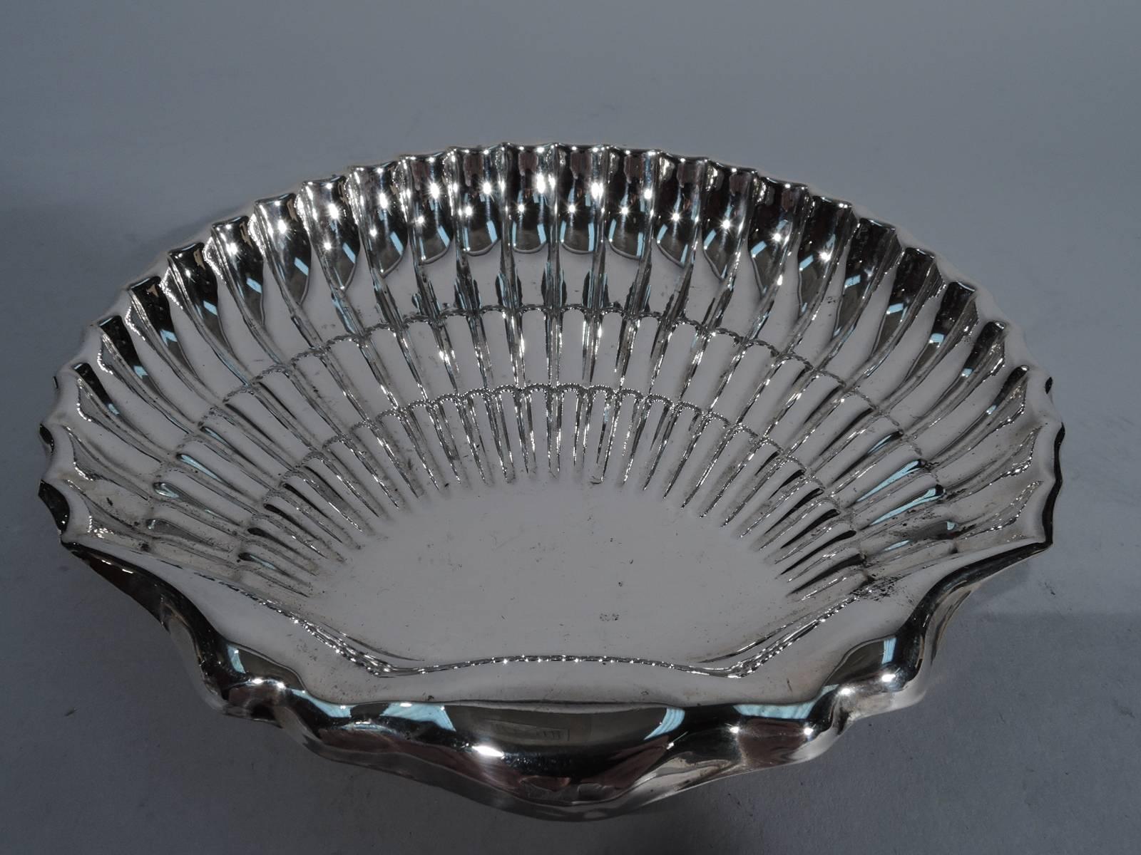 Sterling silver scallop shell. Made by Fisher in New York. Straight and tiered flutes, scrolled rim and two ball supports. Hallmark includes no. 142. Very good condition.

Dimensions: H 1 x W 6 1/4 x D 6 3/8 in. Weight: 4.0 troy ounces. BM626.