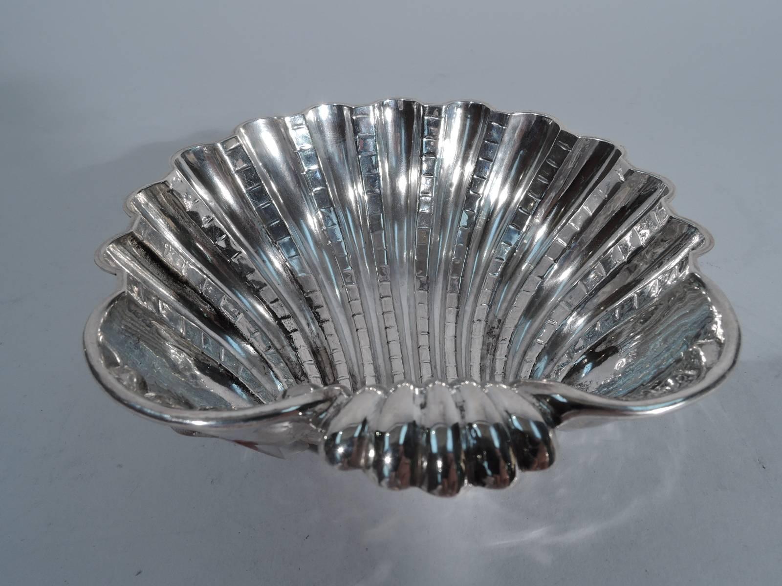 Hand-hammered sterling silver scallop shell. Made by Carla De Boni in Padua for Missiaglia in Venice. Deep bowl and swooshing flutes with incised hatching. Rests on three seashell supports. Tactile and dynamic interpretation of traditional