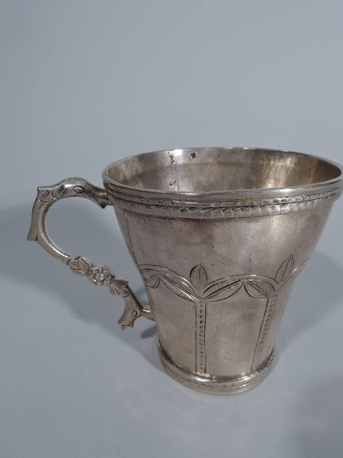 South American silver mug with snake handle, circa 1850. Handmade. Tapering sides with engraved palm tree arcade. Applied and notched rim and base. Engraved snake-form handle with flowers. Weight: 7 troy ounces.  