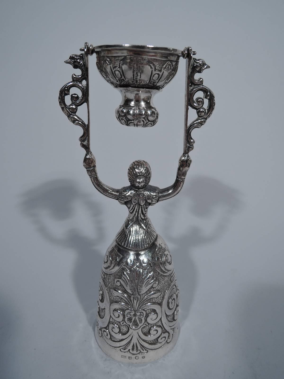 Dutch 934 silver wedding (or wager) cup. 16th-century lady with raised head and hair tied in chignon. Tightly fitting bodice over bosomy figure. Bell skirt has chased strapwork and foliage on stippled ground as well as engraved palmettes and lozenge