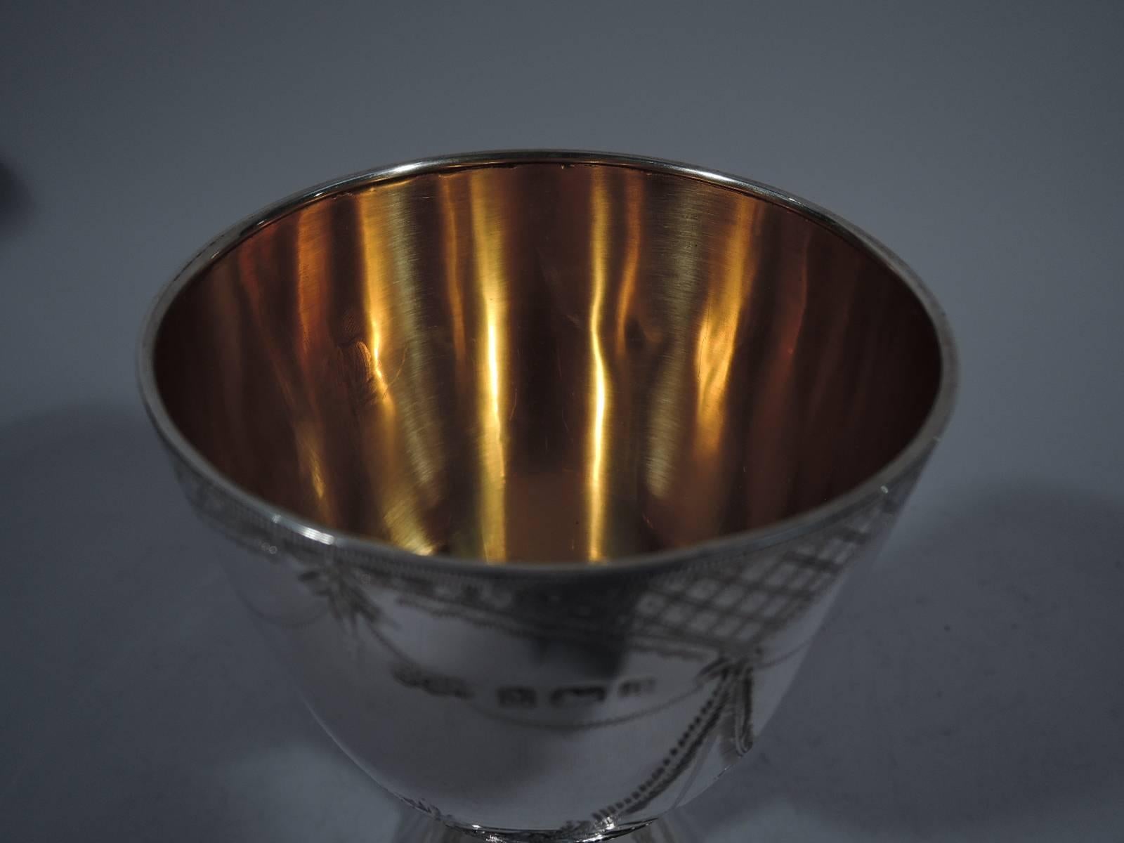 Edwardian sterling silver goblet. Made by Joseph Gloster in Birmingham in 1909. Bowl has curved base and is mounted to concave stem and dome foot. Bowl has four cartouches (vacant) formed by engraved diaper ground and floral garlands. Scrolled and