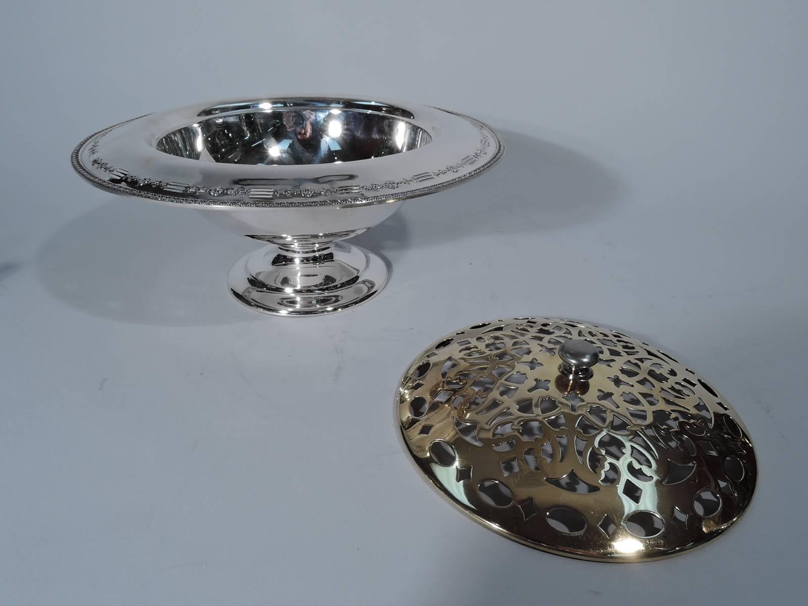 Sterling silver vase with brass frog. Made by Reed & Barton in Taunton, Mass., circa 1915. Round bowl with turned-down rim and stepped foot. Rim has low-relief leaf-and-dart border and floral garland alternating with pierced horizontal lines. Frog