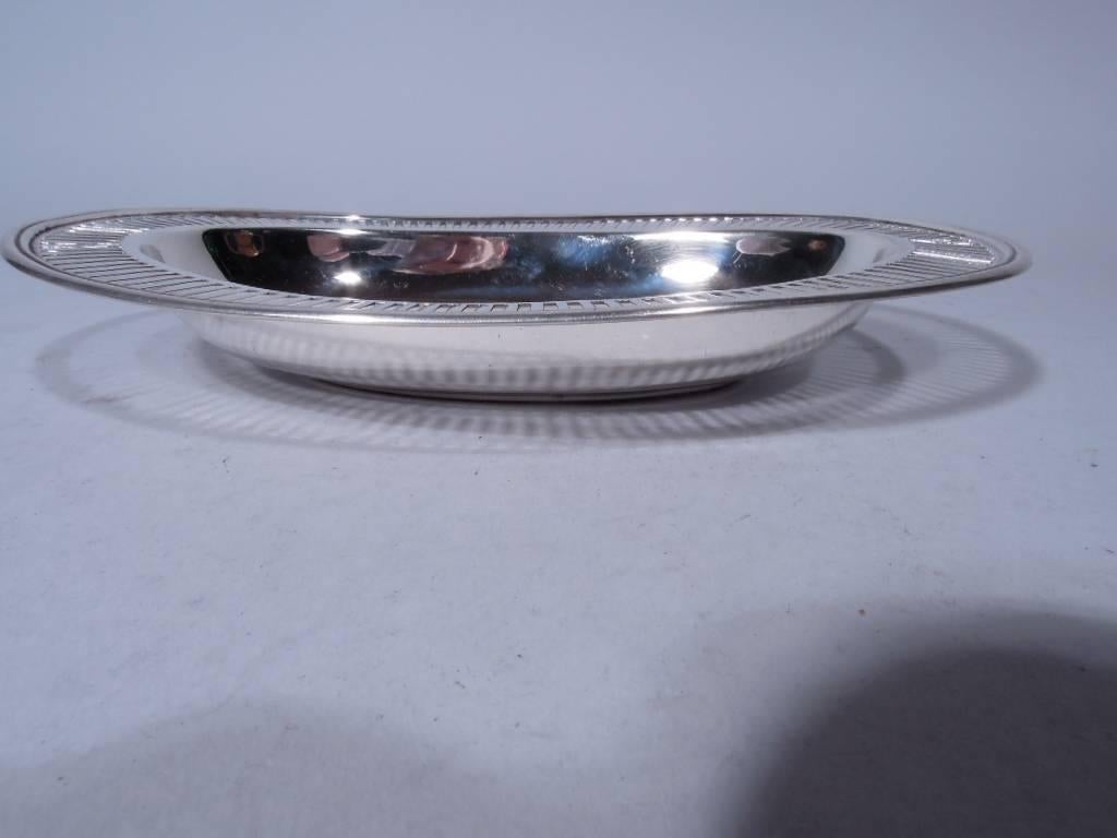 Edwardian sterling silver bowl. Made by Tiffany & Co. in New York, ca 1907. Solid oval well with curved sides. Flat and molded rim with linear piercing. Smart and dynamic. Hallmark includes pattern no. 17109 (first produced in 1907) and director’s