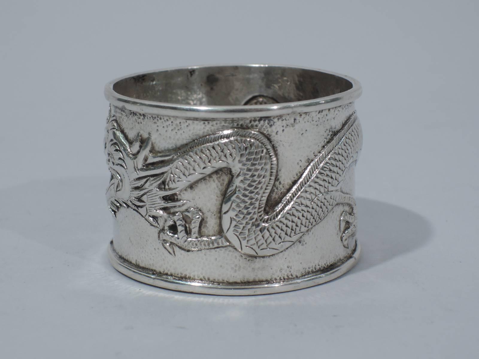 Chinese export silver napkin ring with chased and repousse wraparound dragon on stippled ground. Between snout and tail is circular plate with interlaced monogram BL. Appears to be unmarked. Excellent quality and condition.

Dimensions: H 1 1/4 x